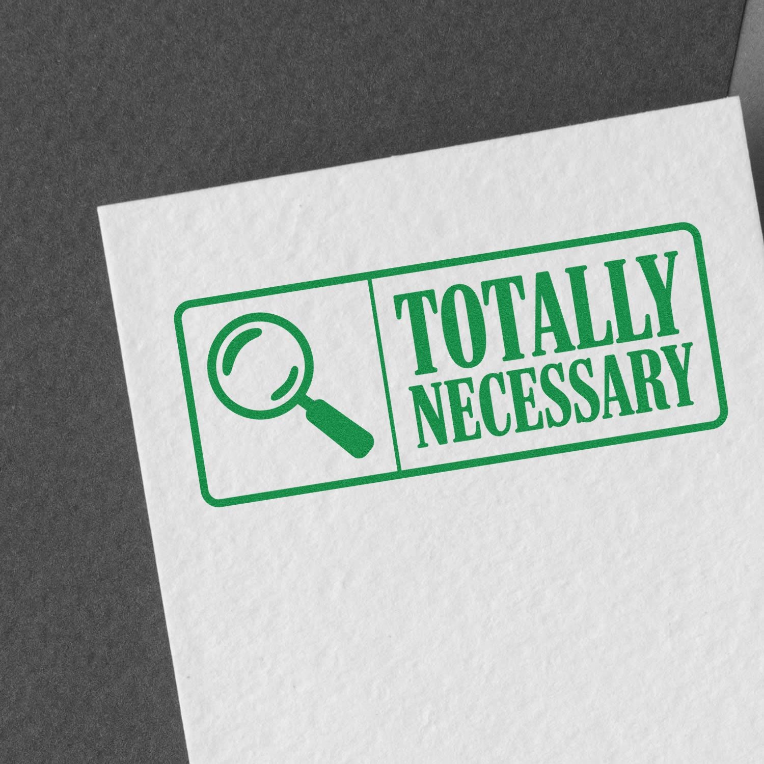 Green Totally Necessary rubber stamp with magnifying glass icon on paper, ideal for novelty office branding.