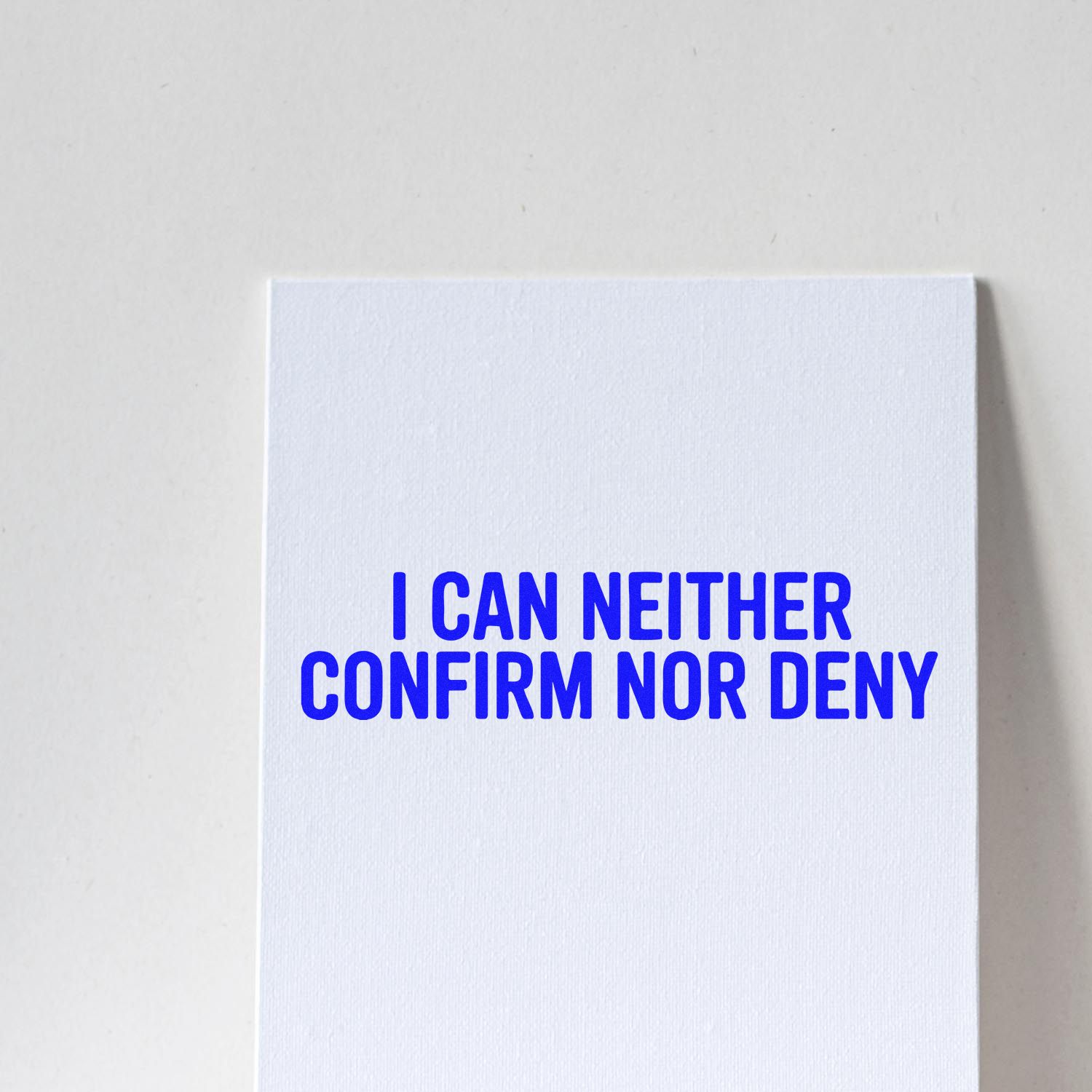 Novelty rubber stamp with bold blue text: I can neither confirm nor deny for office humor and secretive replies.