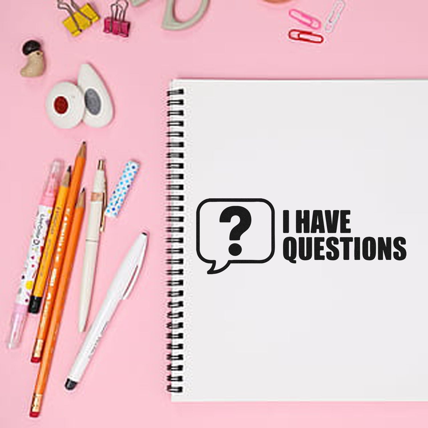 I Have Questions rubber stamp on notebook with school supplies, ideal for classroom organization and teacher feedback.