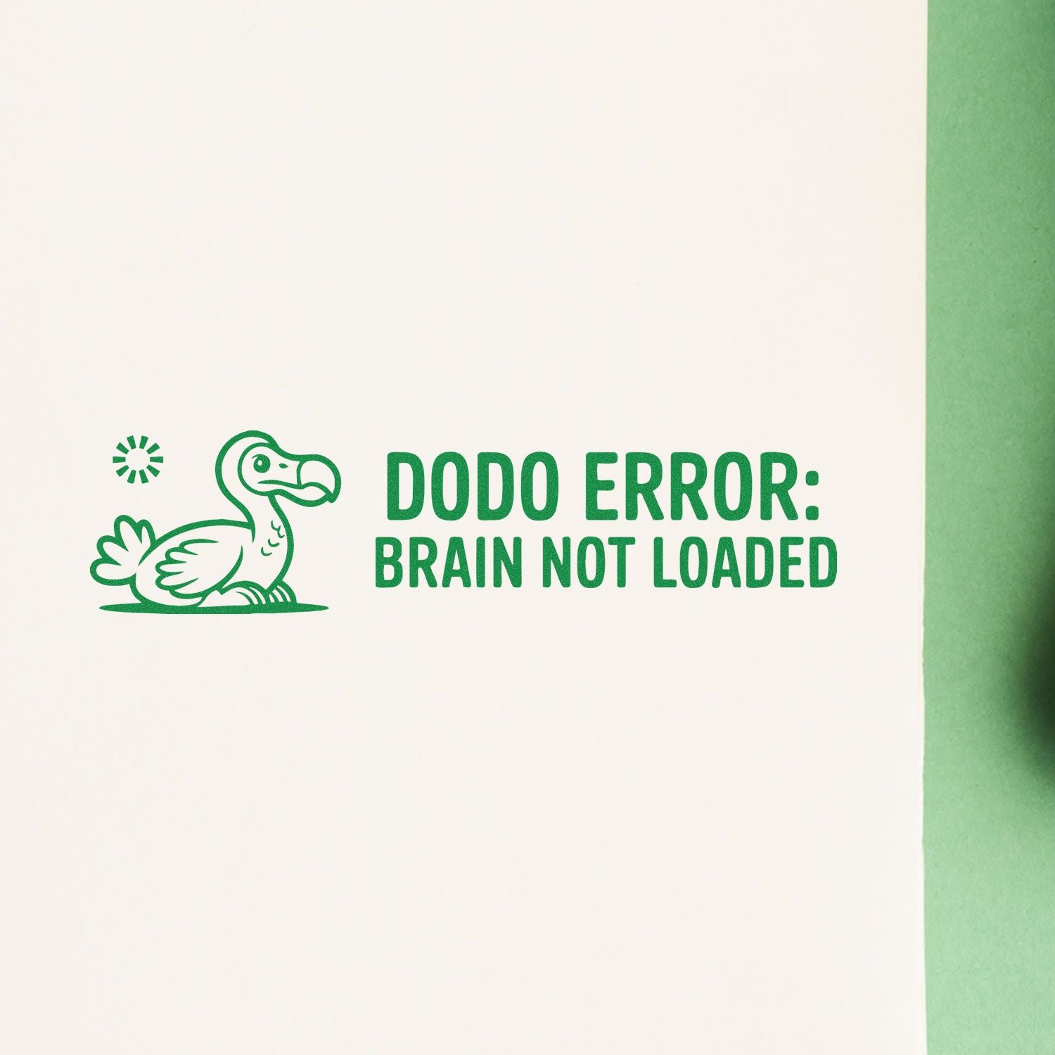 Green rubber stamp design with dodo bird and DODO ERROR: BRAIN NOT LOADED text on white paper.