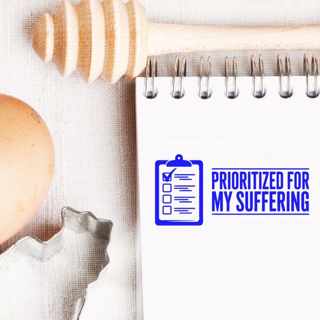 Humorous rubber stamp imprint on notepad reading Prioritized for My Suffering, a checklist stamp for planners, office, and stationery use.