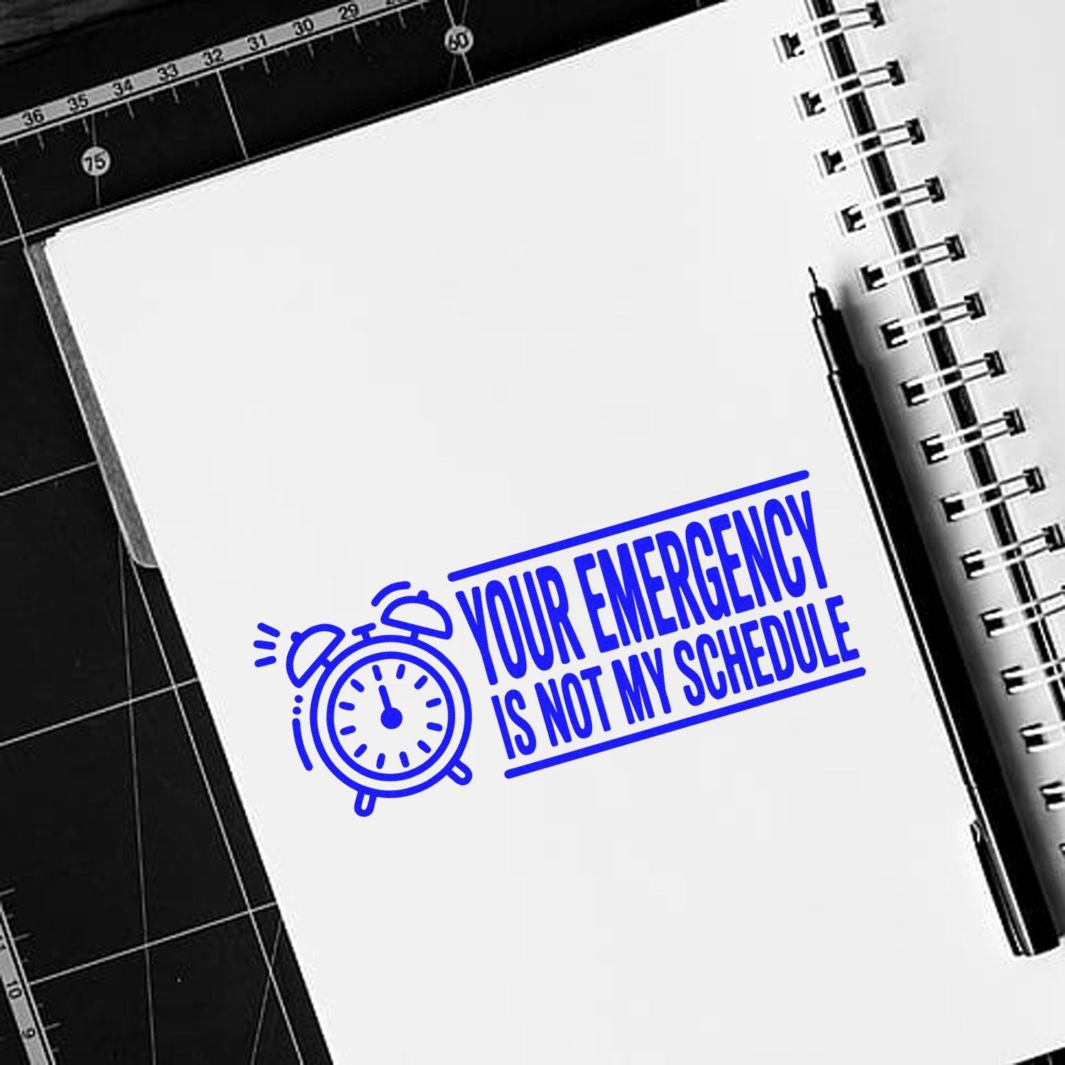 Custom rubber stamp design with alarm clock icon and Your emergency is not my schedule on a notebook page.