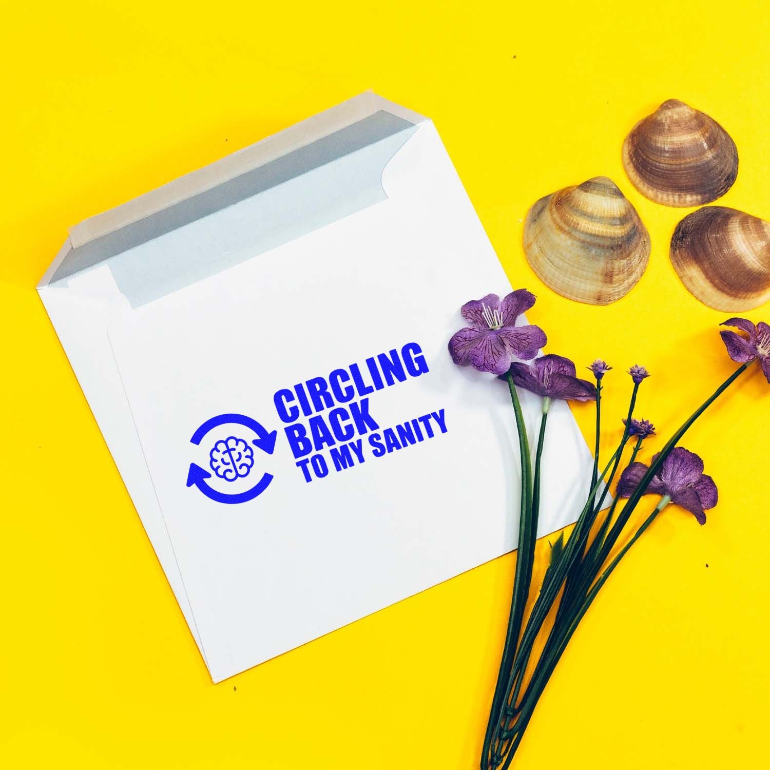Custom rubber stamp design reading Circling back to my sanity on a white envelope with flowers and seashells.
