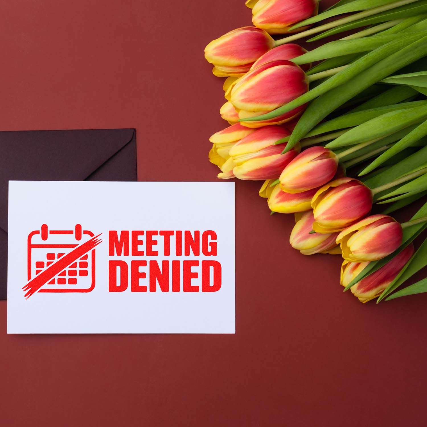 Meeting Denied rubber stamp on a card beside tulips and an envelope, ideal for office humor, rejection notices, and stationery.