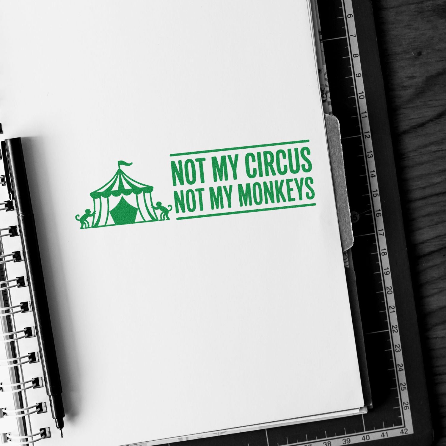 Green rubber stamp design reading Not My Circus, Not My Monkeys with circus tent and monkeys on notebook page.