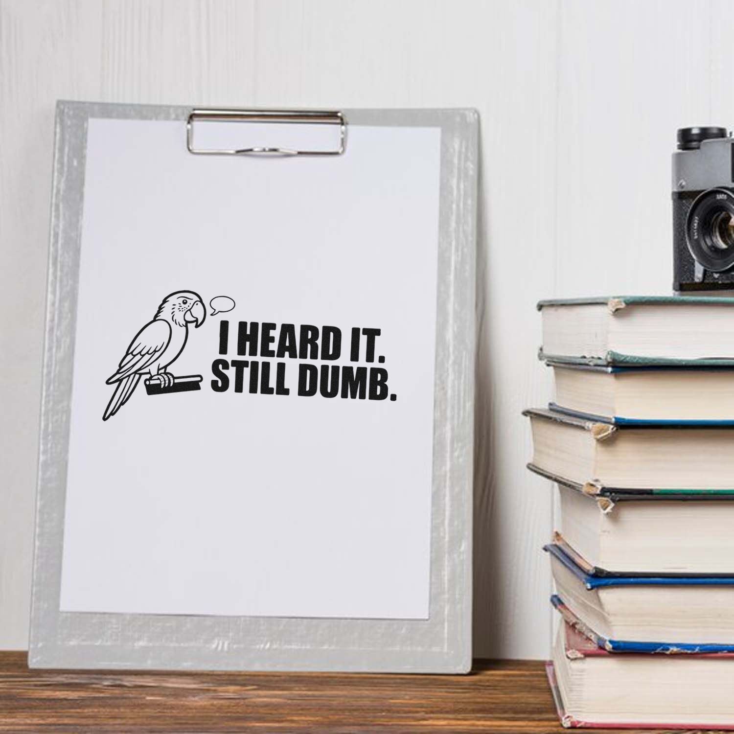 Funny rubber stamp design with parrot and I Heard It. Still Dumb. quote, ideal for sarcastic stationery and craft projects.