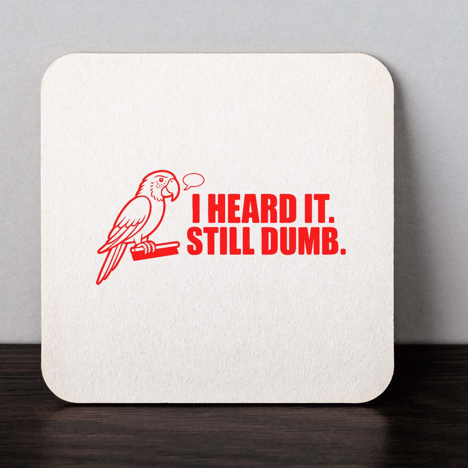 Red parrot rubber stamp design with I Heard It. Still Dumb. text for funny office, crafting, or gift packaging use.