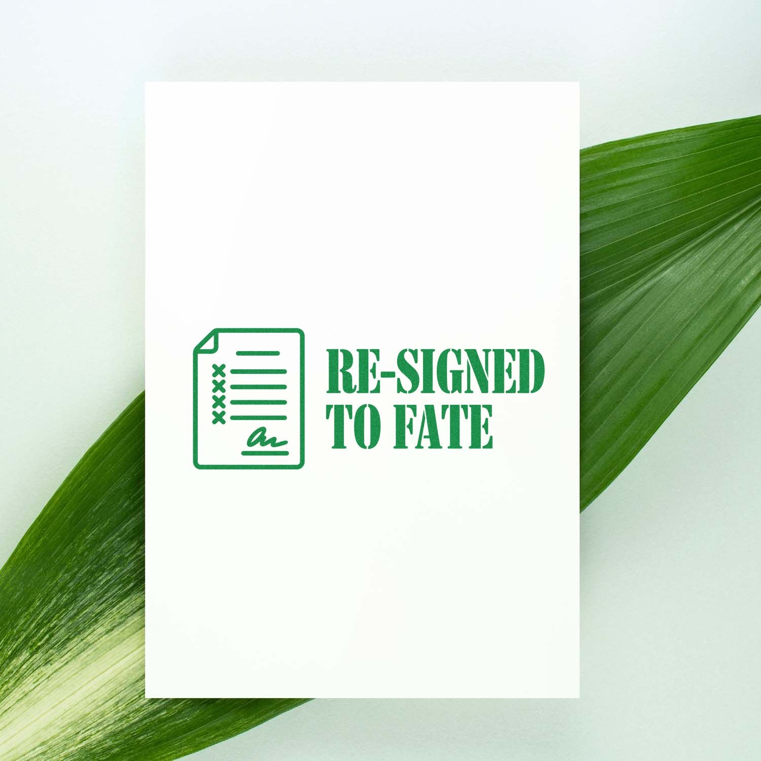 Green rubber stamp design reading Re-Signed to Fate with document icon, shown on a white card for custom stamp products.