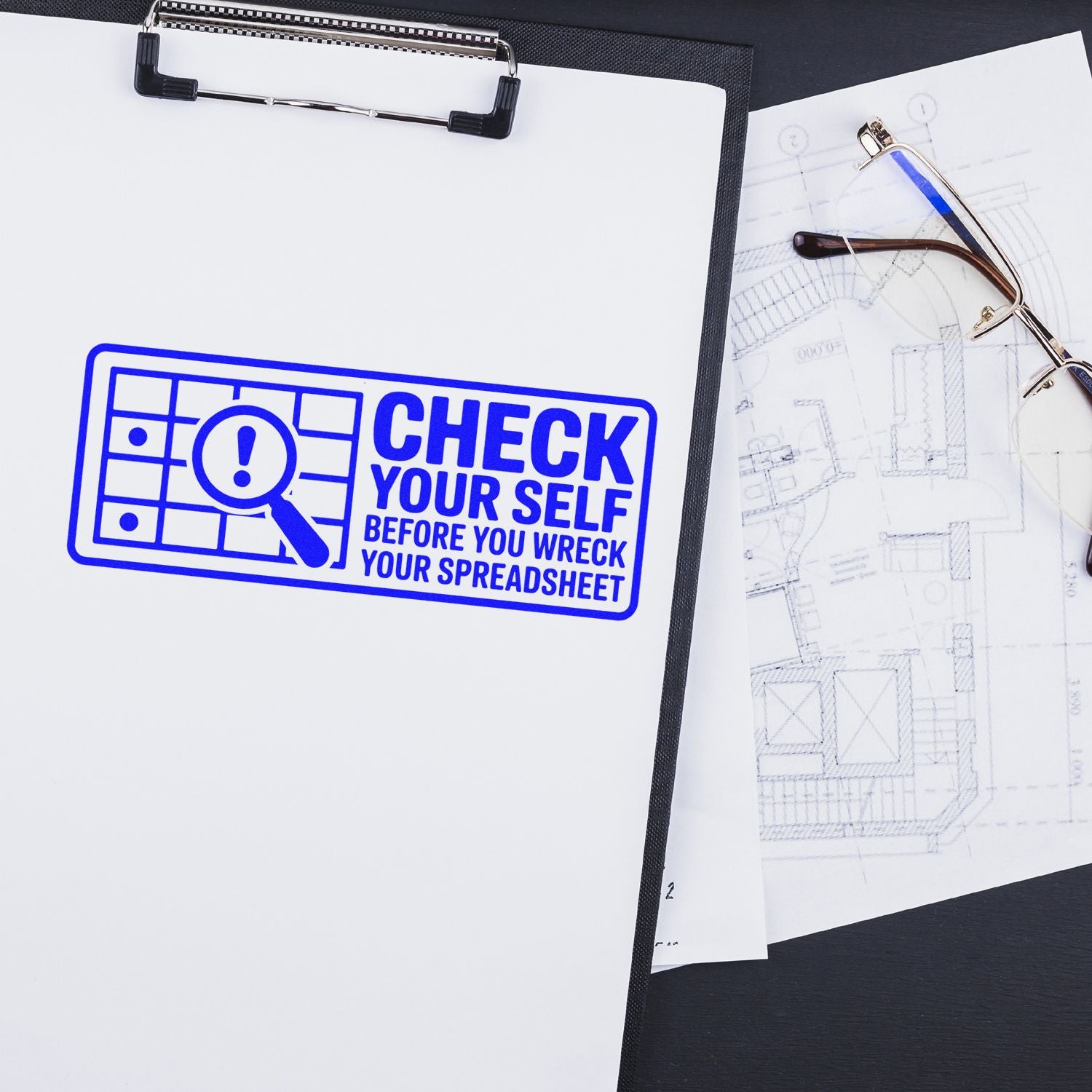 Custom rubber stamp on clipboard reads Check Yourself Before You Wreck Your Spreadsheet for office proofreading and spreadsheet accuracy.