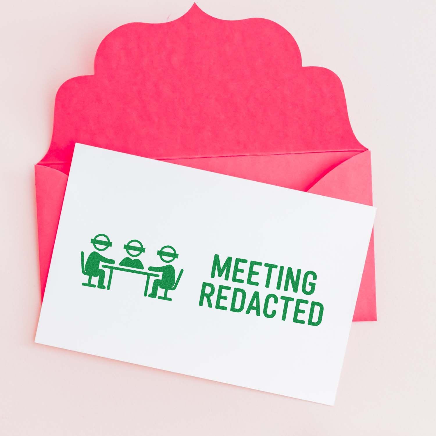 Meeting Redacted rubber stamp design on a card in a pink envelope for office privacy and confidential document marking.