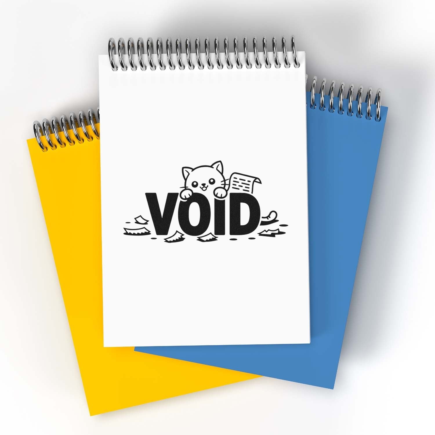 Void rubber stamp design on a spiral notebook, featuring a playful cat and paper scraps for office use.