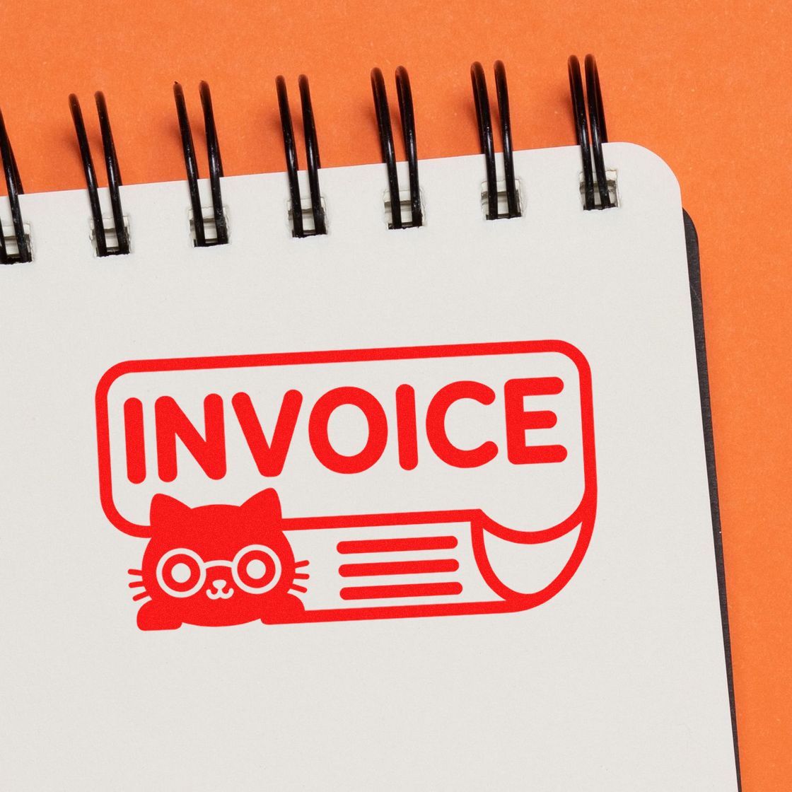 Invoice rubber stamp with cat design for accounting, billing, and office paperwork on a notebook page.