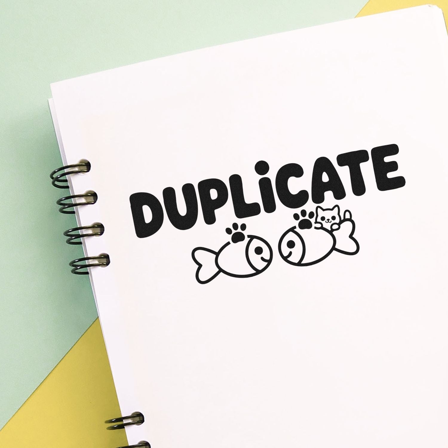 Duplicate rubber stamp design with playful fish and cat graphic on notebook paper, ideal for custom office or craft stamping.