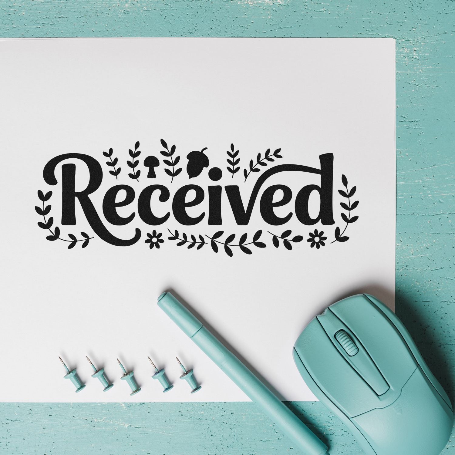 Decorative Received rubber stamp design with floral accents, showing a custom office mail stamp and teal stamping tools.