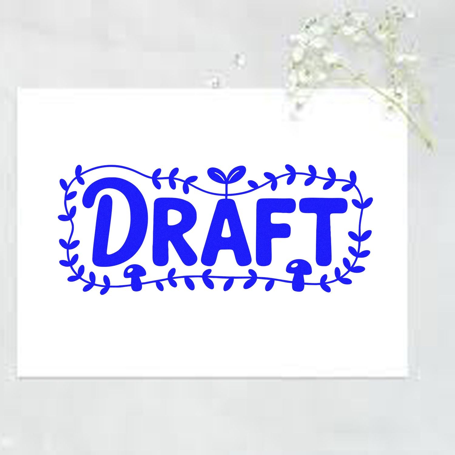 Blue DRAFT rubber stamp with leafy botanical frame for document review, approvals, and office labeling.
