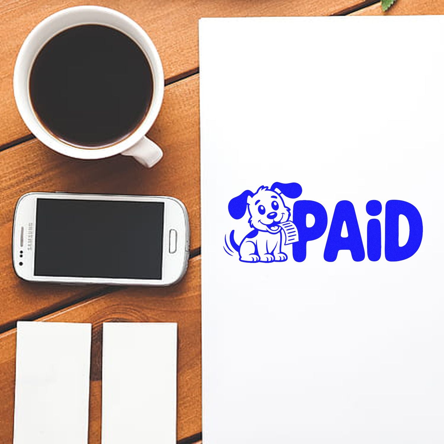 Custom PAID rubber stamp with dog logo on paper, shown on a desk beside coffee cup, smartphone, and blank notes.