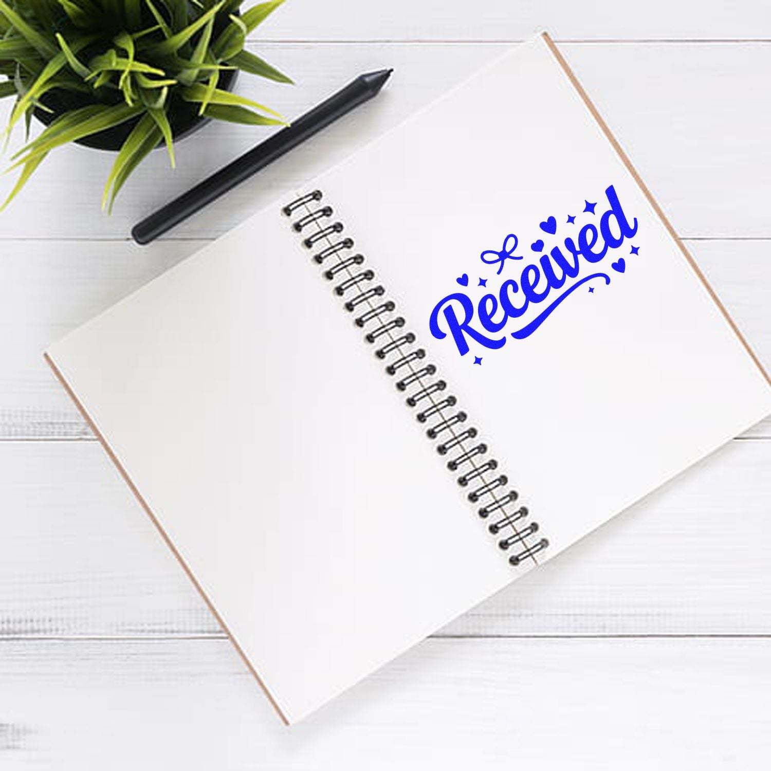 Blue Received rubber stamp on open spiral notebook, ideal for office document processing.