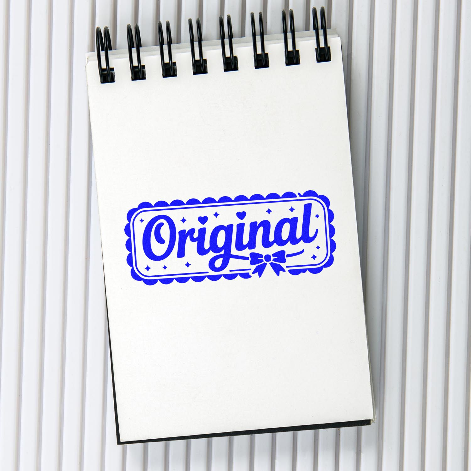 Blue Original rubber stamp design on a spiral notepad, ideal for custom branding, packaging, and handmade product labels.