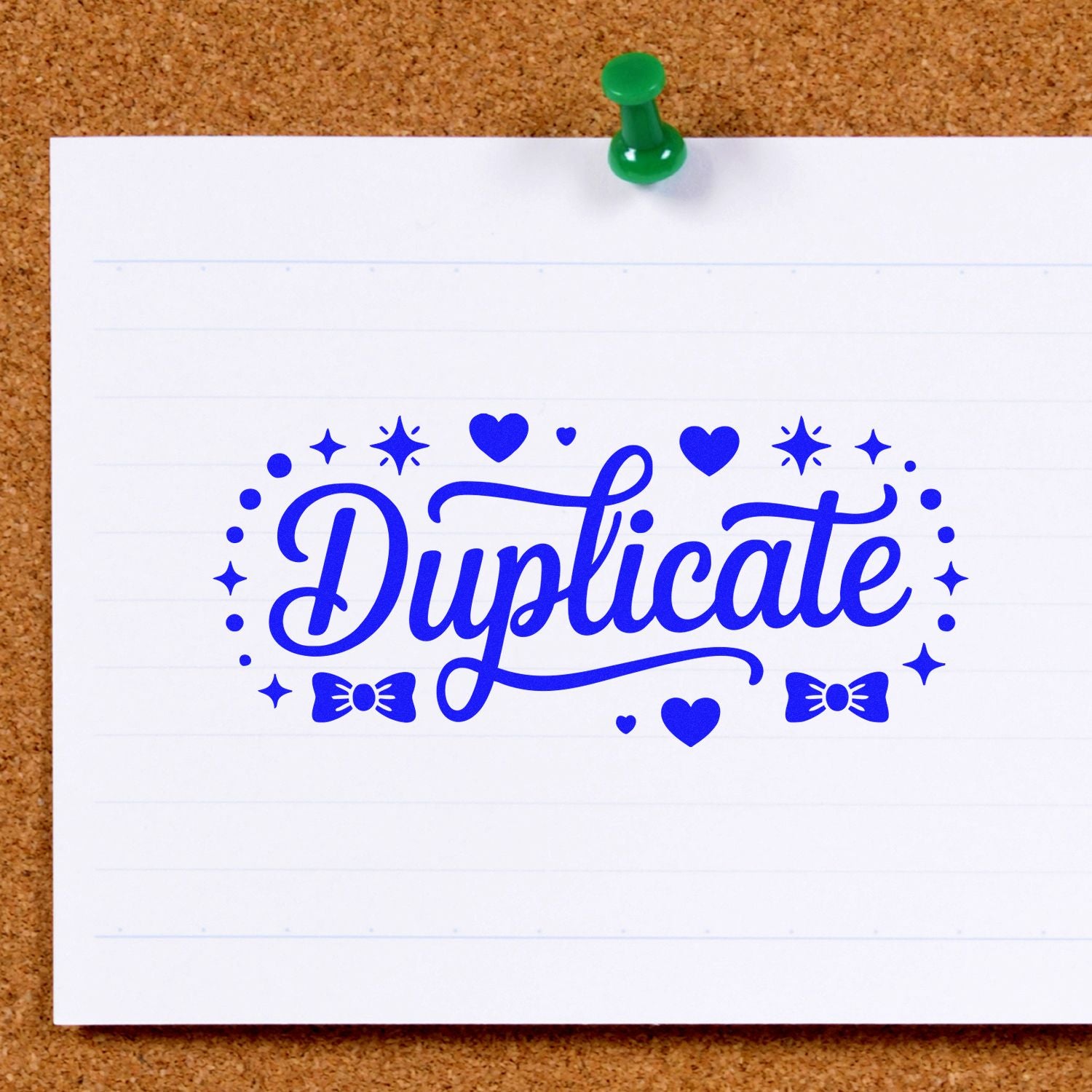 Blue duplicate rubber stamp impression with hearts and stars on lined paper, pinned to a corkboard.