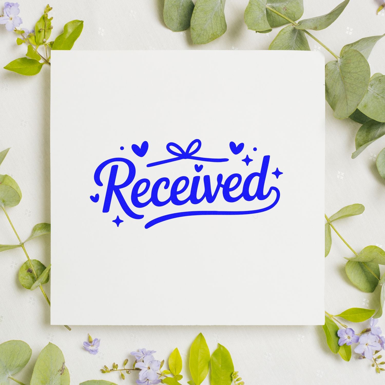Blue Received decorative script rubber stamp design on white card with floral greenery mockup.