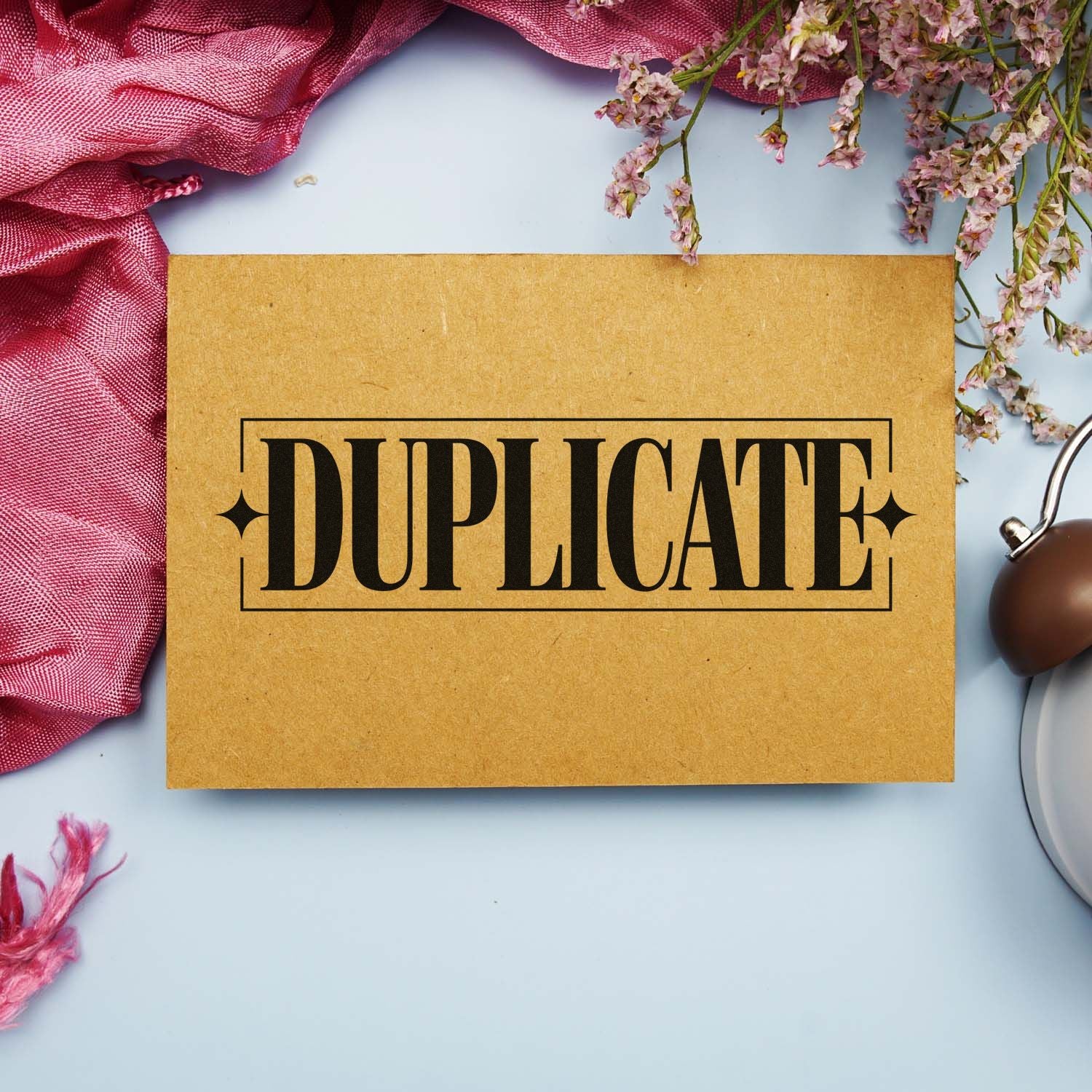 Duplicate rubber stamp on kraft paper envelope for office document labeling, file sorting, and mailing organization.