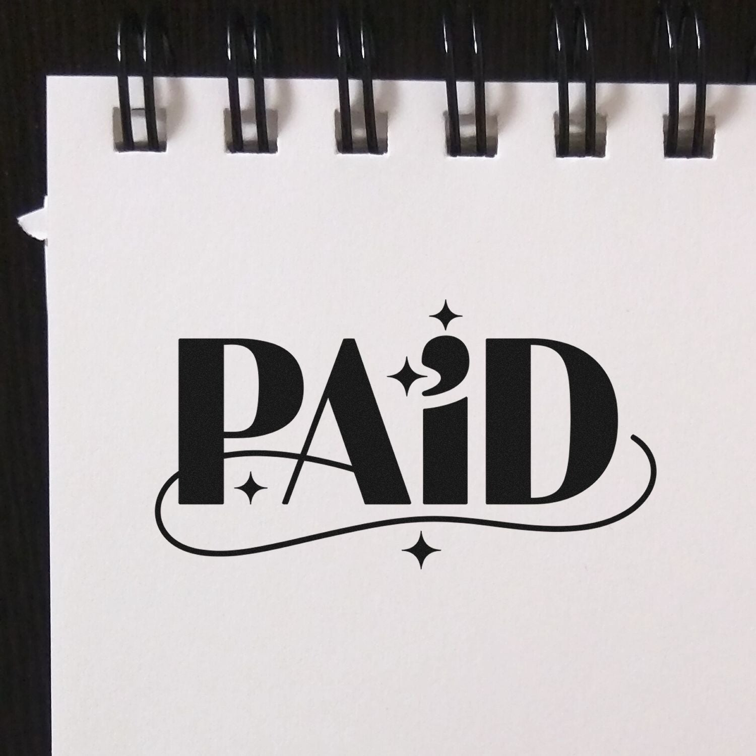 Black PAID rubber stamp design with decorative lettering and stars for invoices, receipts, and business accounting.