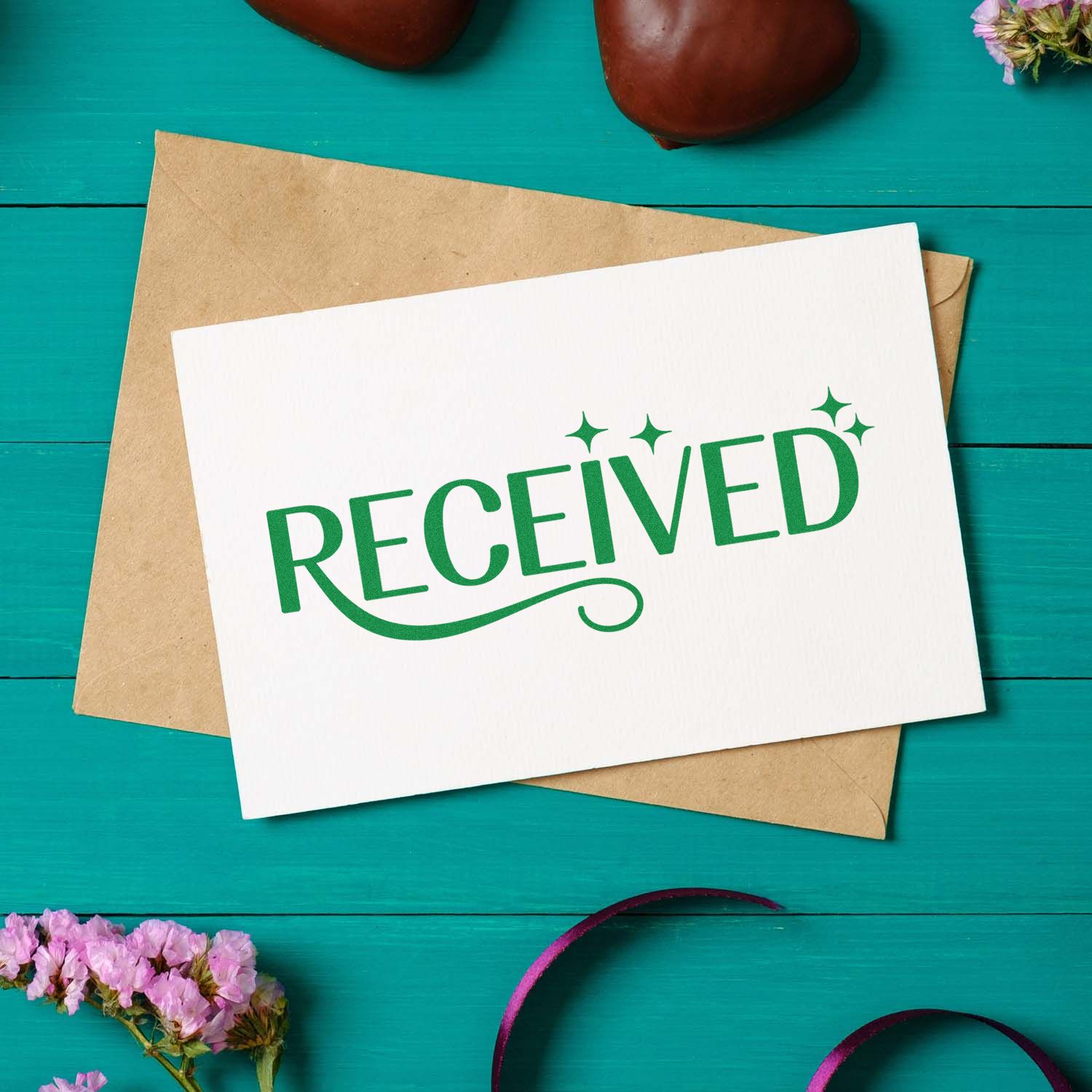 Green Received rubber stamp on a card over a kraft envelope, ideal for office mail processing and document tracking.