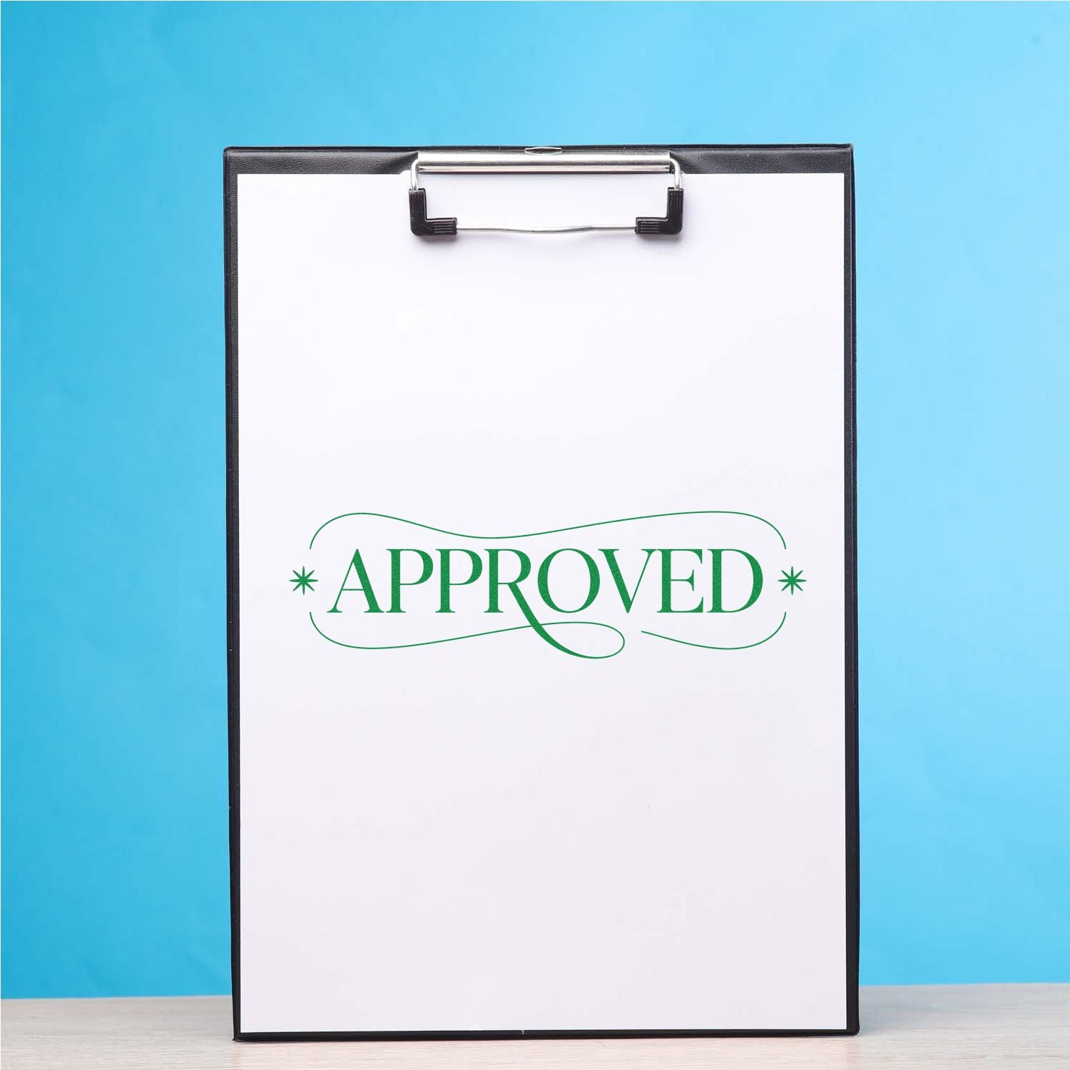 Green approved rubber stamp imprint on clipboard paper for office document approval and workflow tracking.