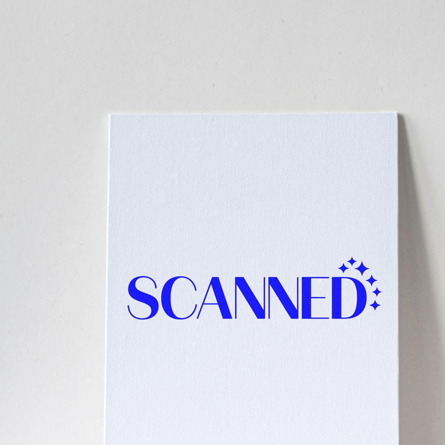 Blue SCANNED rubber stamp design on white cardstock with sparkles, ideal for document processing and office workflow.
