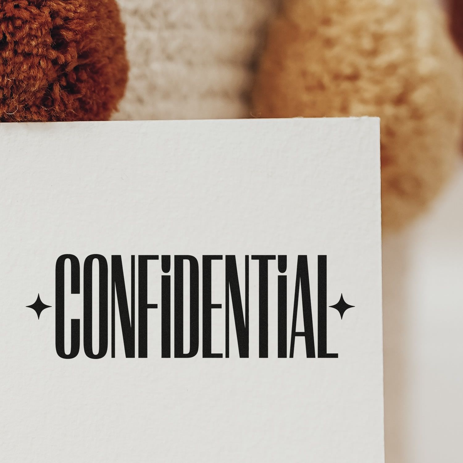 Confidential rubber stamp on white paper for marking private documents, envelopes, and office files.