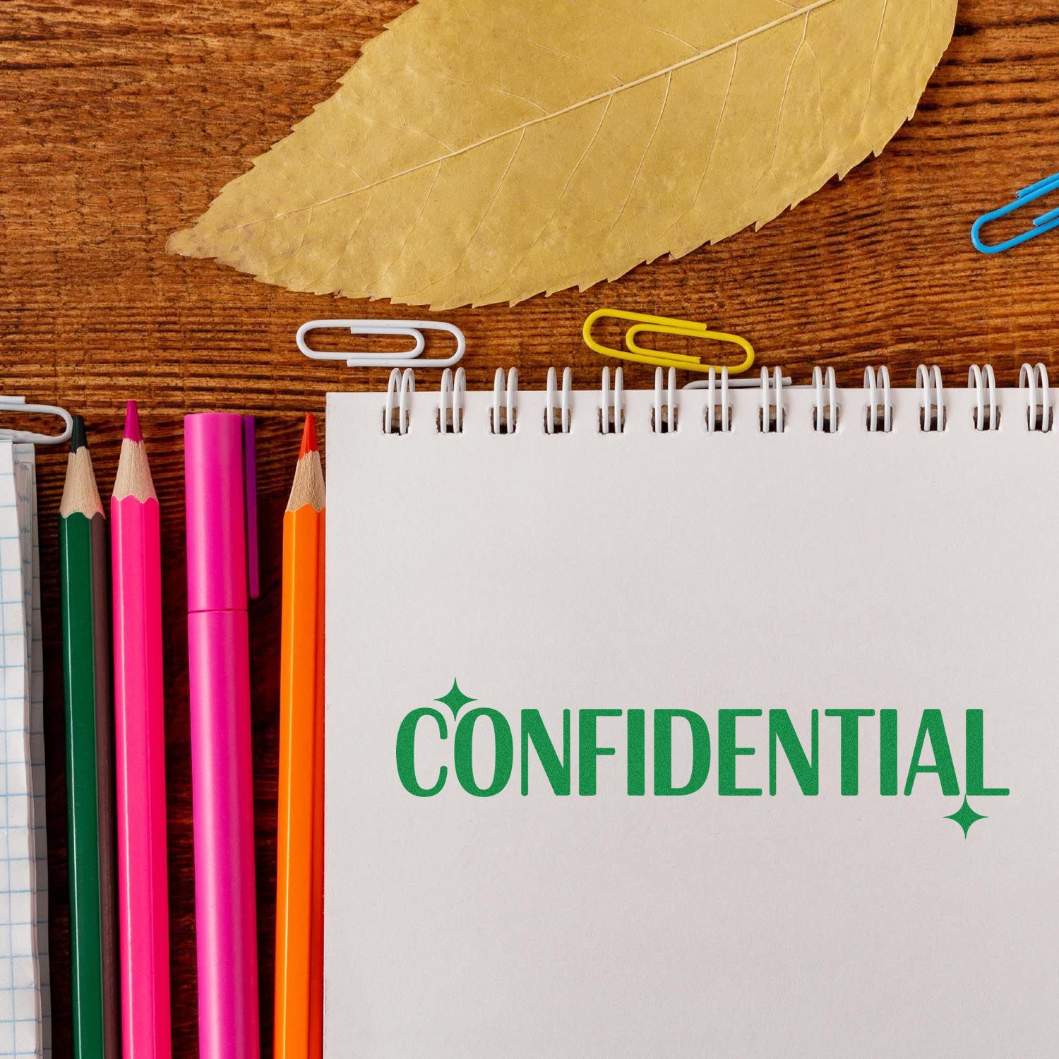 Confidential rubber stamp on notebook with stationery, ideal for office document security, privacy labeling, and legal paperwork.