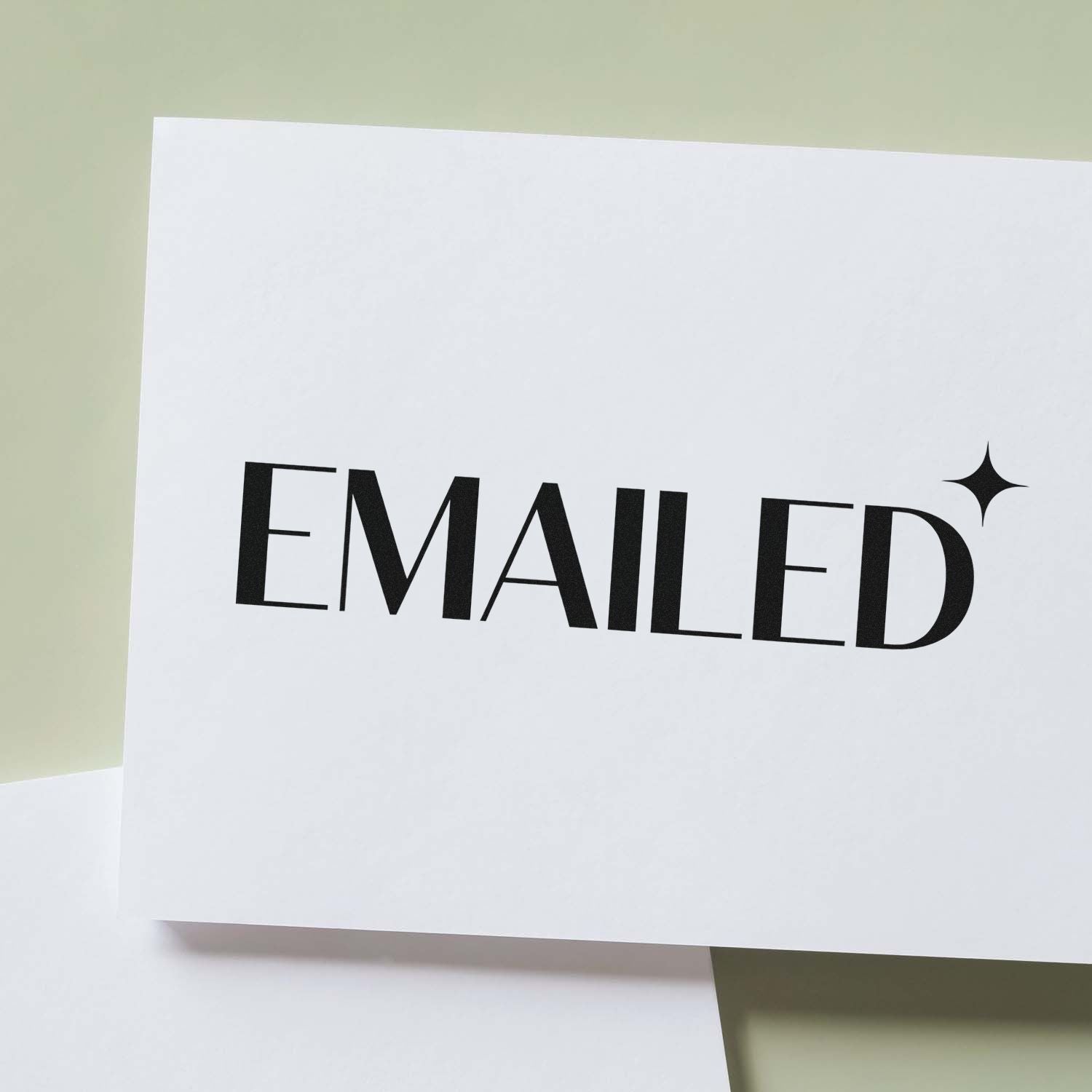 Custom rubber stamp impression reading Emailed on white paper for office mail tracking and document organization.