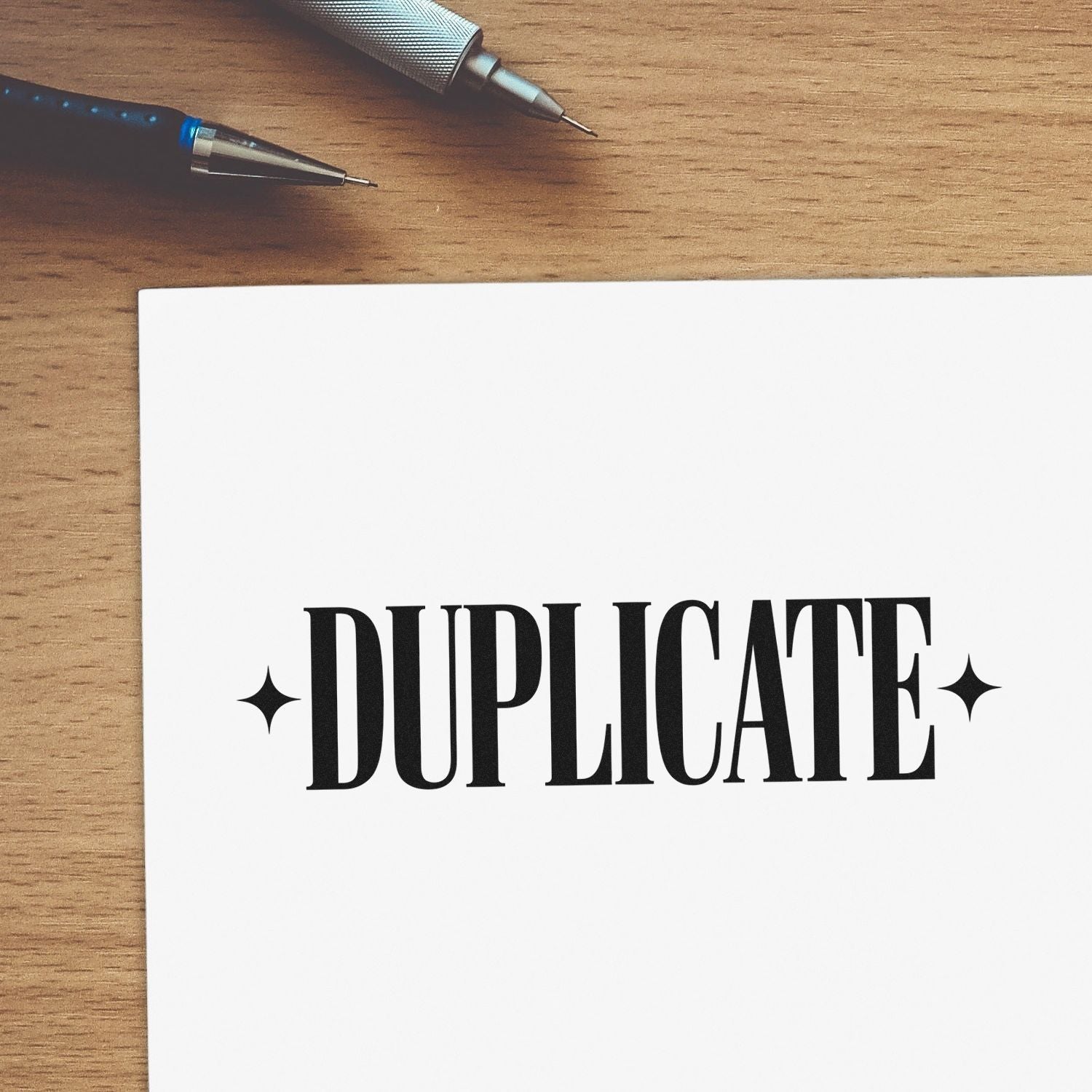 Duplicate rubber stamp impression on paper with pens, ideal for office document processing and copy labeling.
