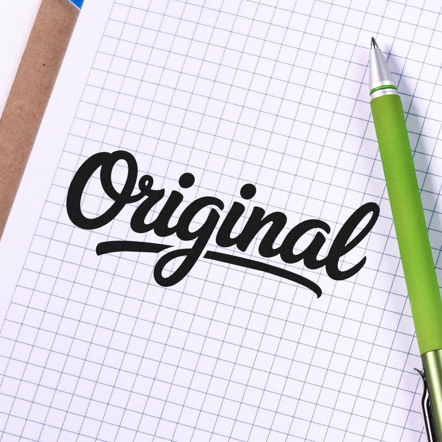 Original script rubber stamp design for branding, crafts, and custom stationery, shown on graph paper with a green pen.