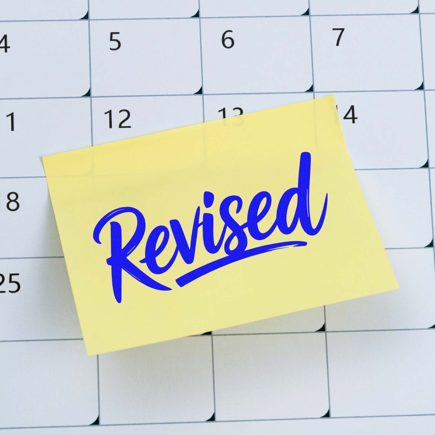 Blue Revised stamp on sticky note over calendar, signaling a document or schedule update.