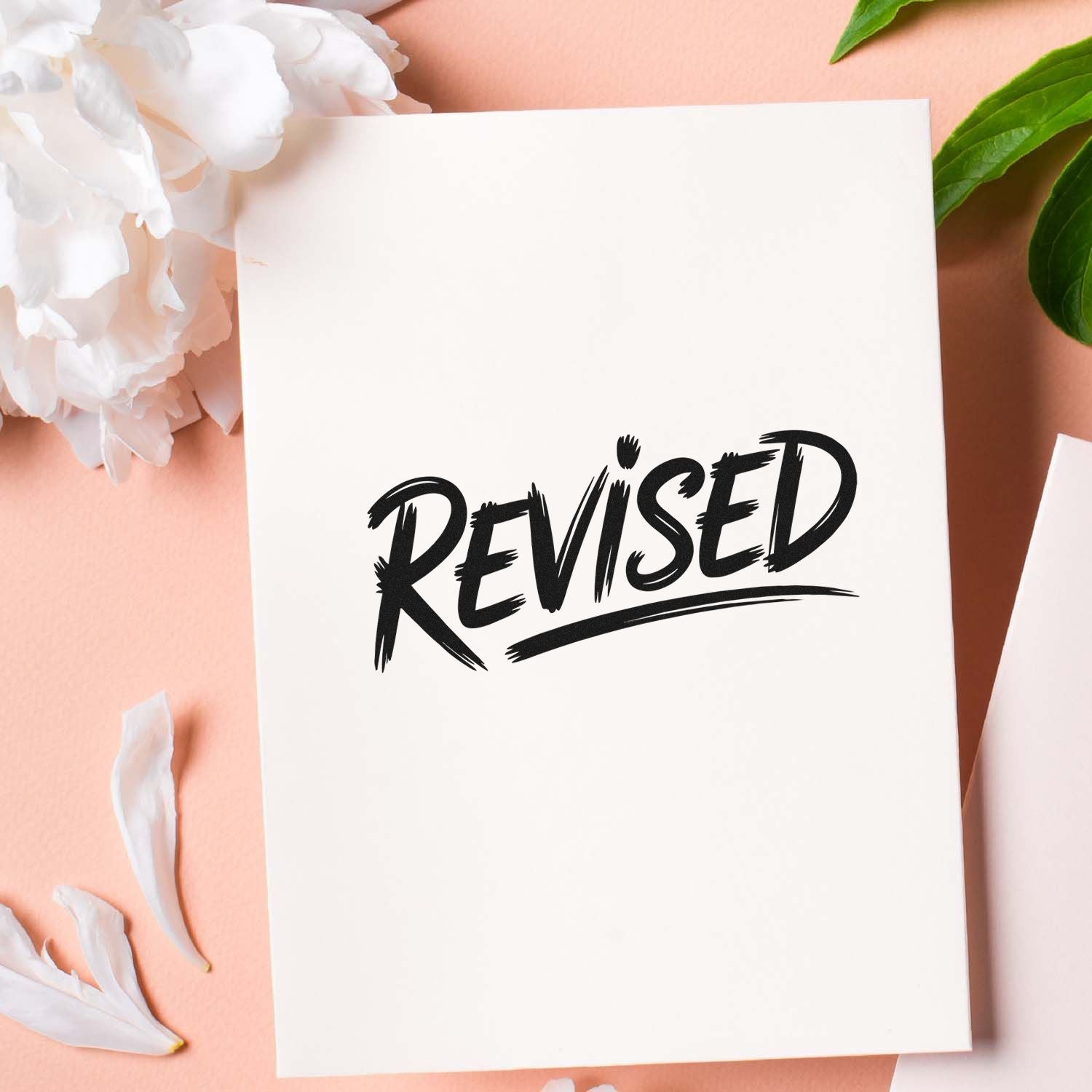Revised rubber stamp on white paper, ideal for document approvals, edits, and office filing.