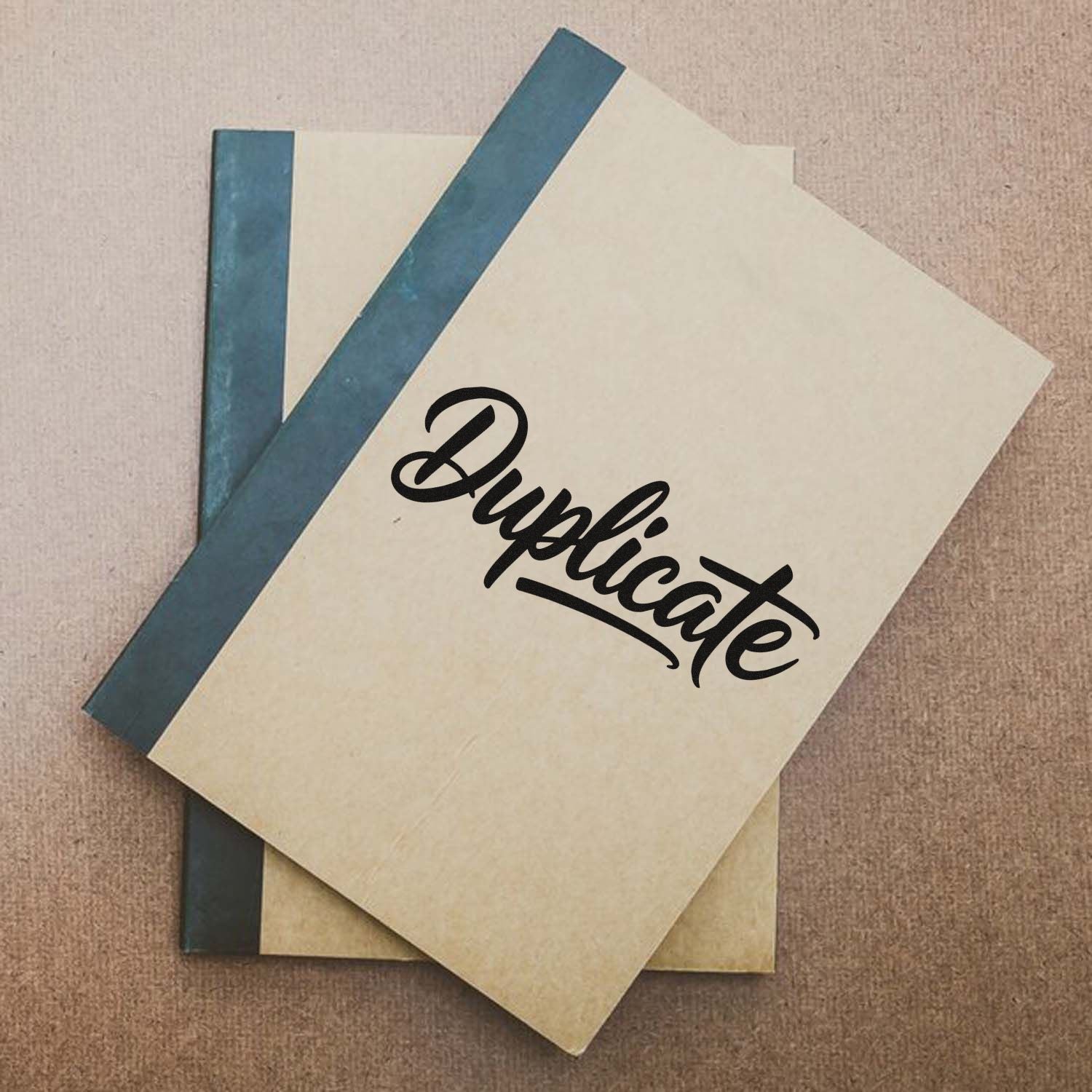 Duplicate rubber stamp impression on stacked office folders and notebooks, marking duplicate documents for filing.