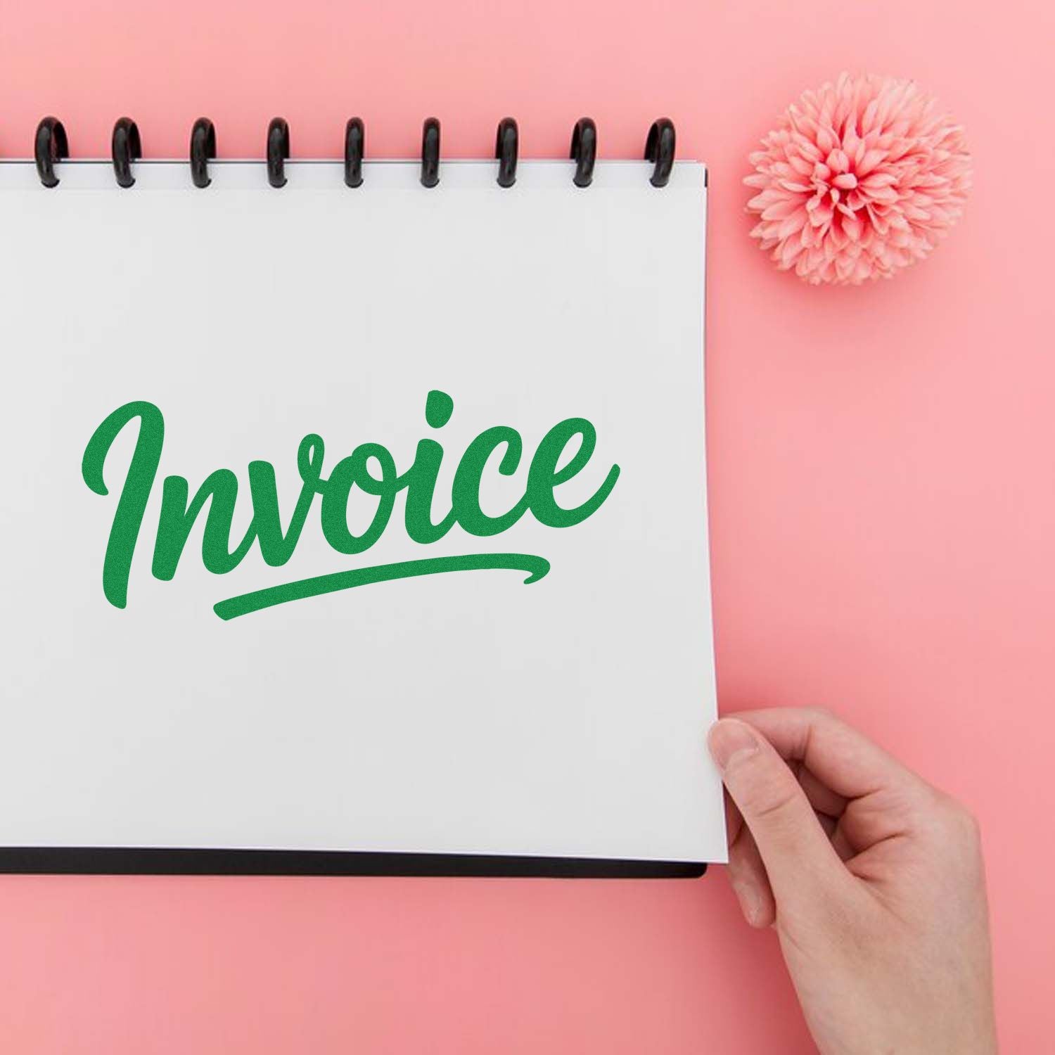 Green invoice rubber stamp on a notebook page for billing, office organization, and accounting.