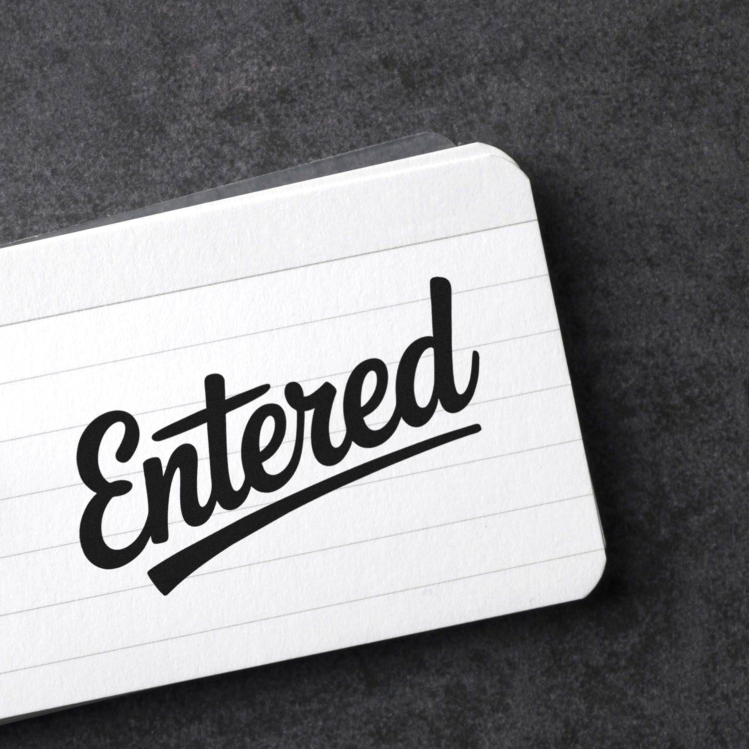 Entered rubber stamp impression on lined paper for office document processing and approval tracking.
