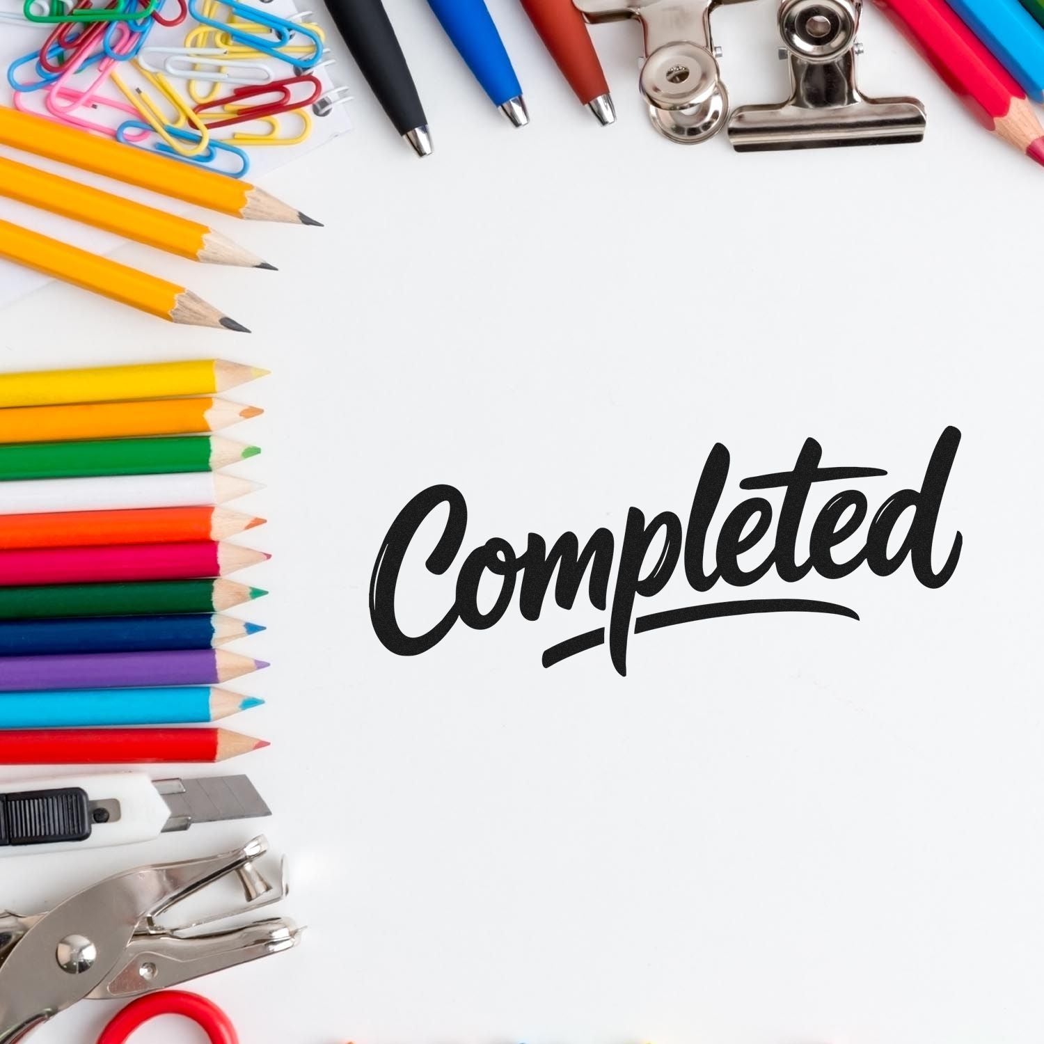 Completed rubber stamp design surrounded by colorful pencils, paper clips, and office supplies for office use.