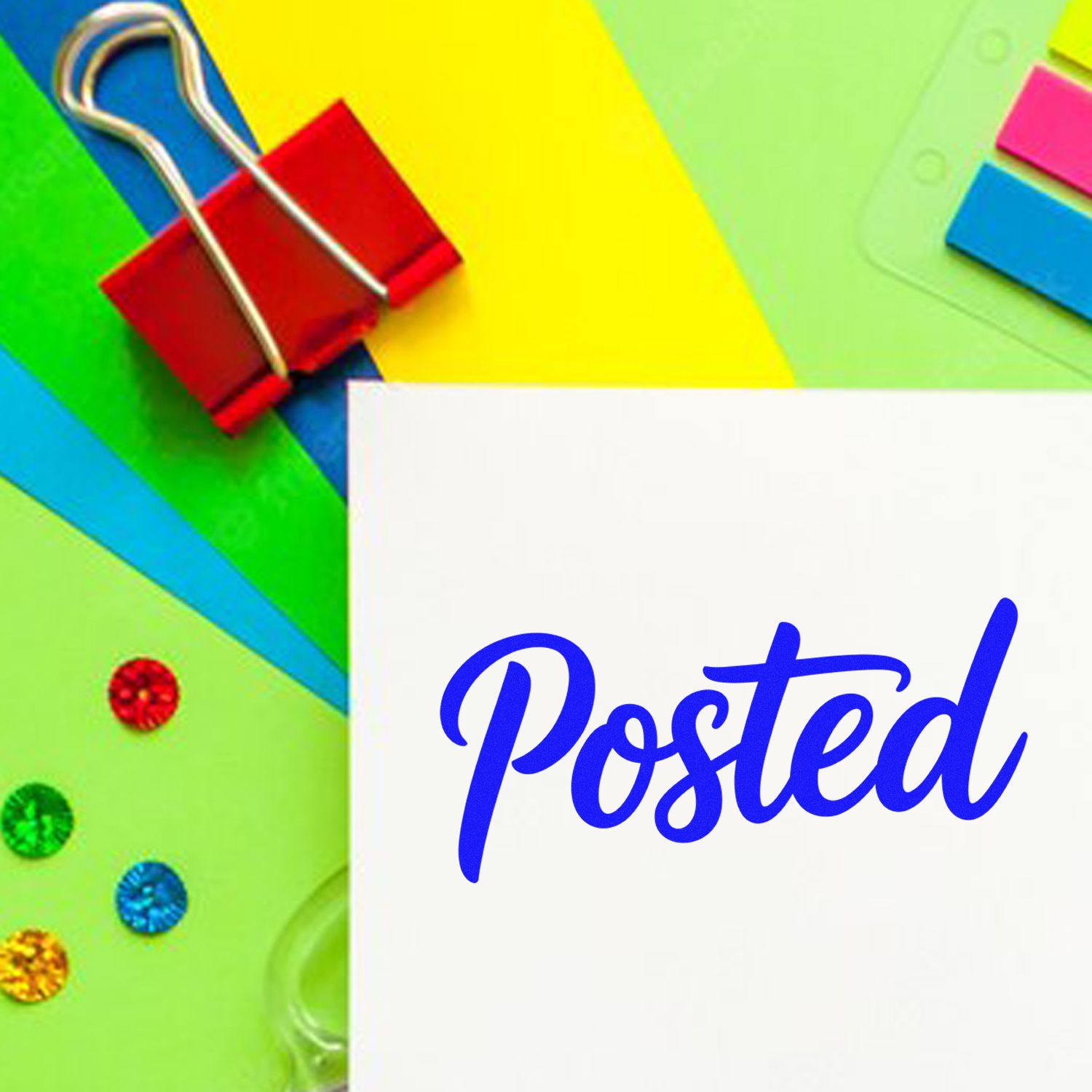 Posted rubber stamp imprint on white paper with colorful office supplies and paper clips.