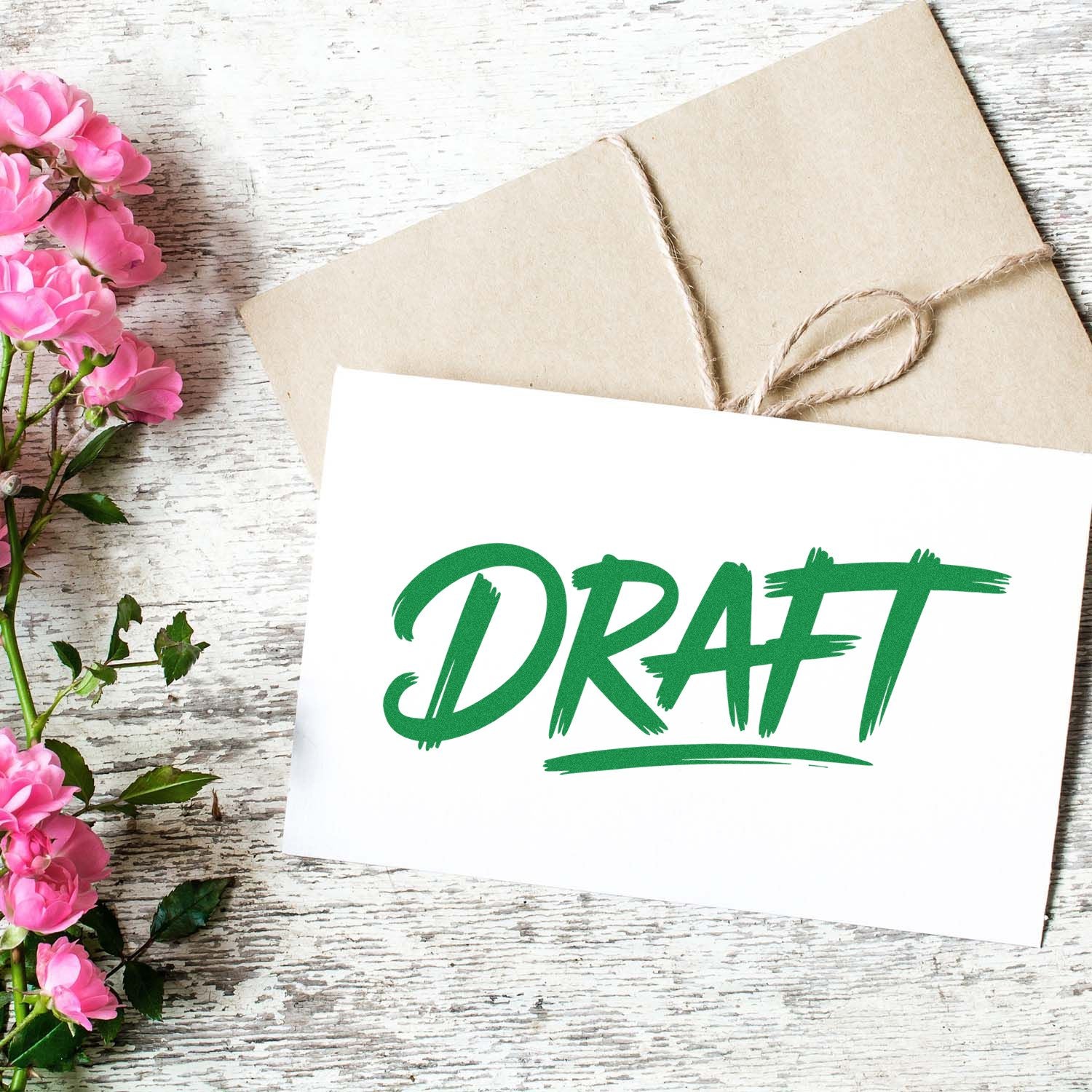 DRAFT rubber stamp impression on a card with envelope and flowers, perfect for document review and approval workflows.