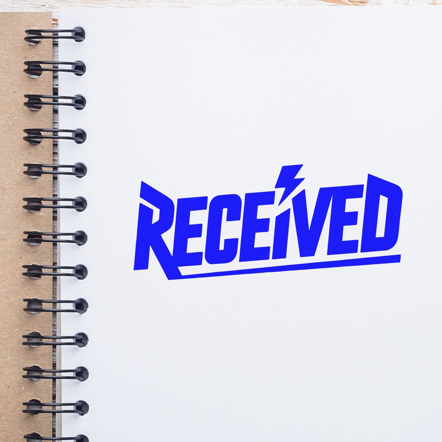 Blue RECEIVED rubber stamp on notebook page for office document approval, mail sorting, and records processing.