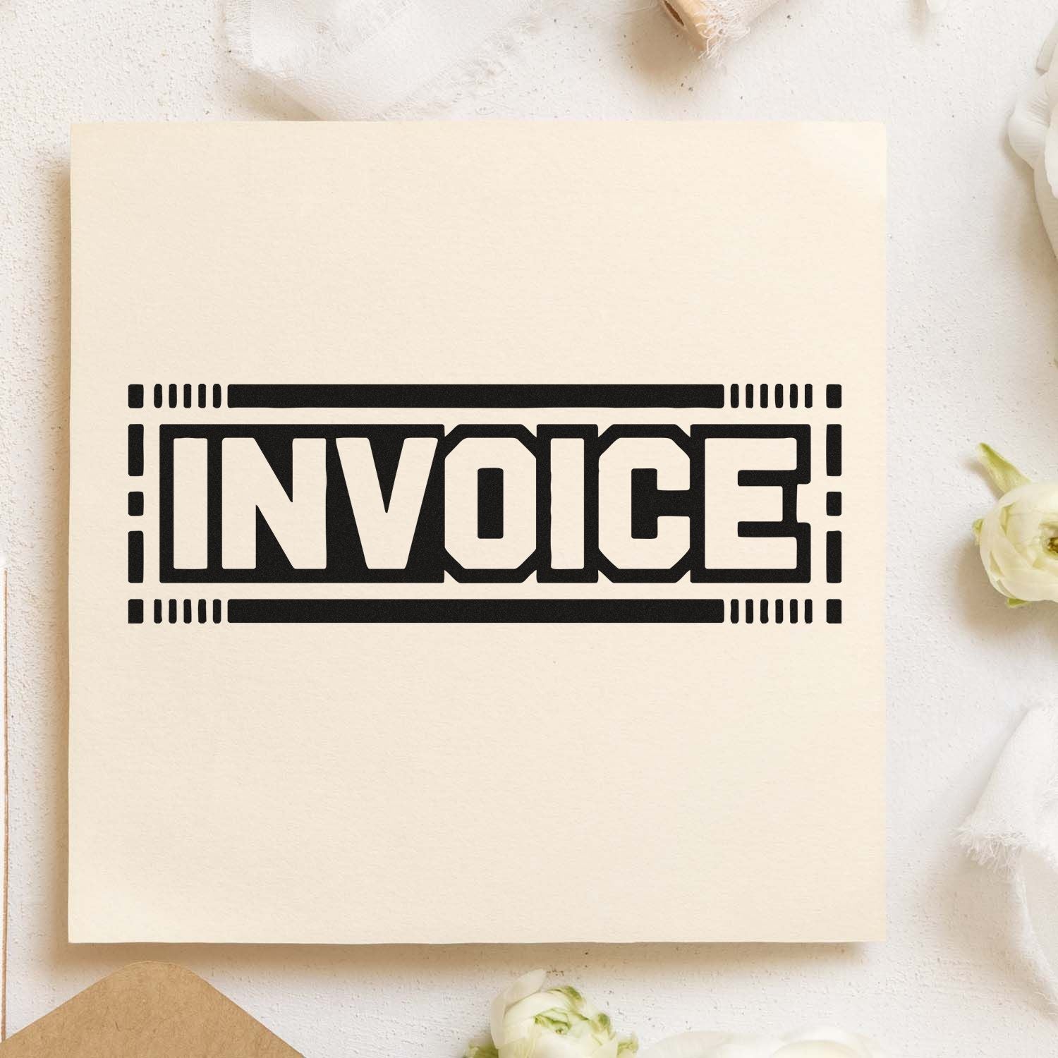 Invoice rubber stamp impression on cardstock for office billing, bookkeeping, and document organization.