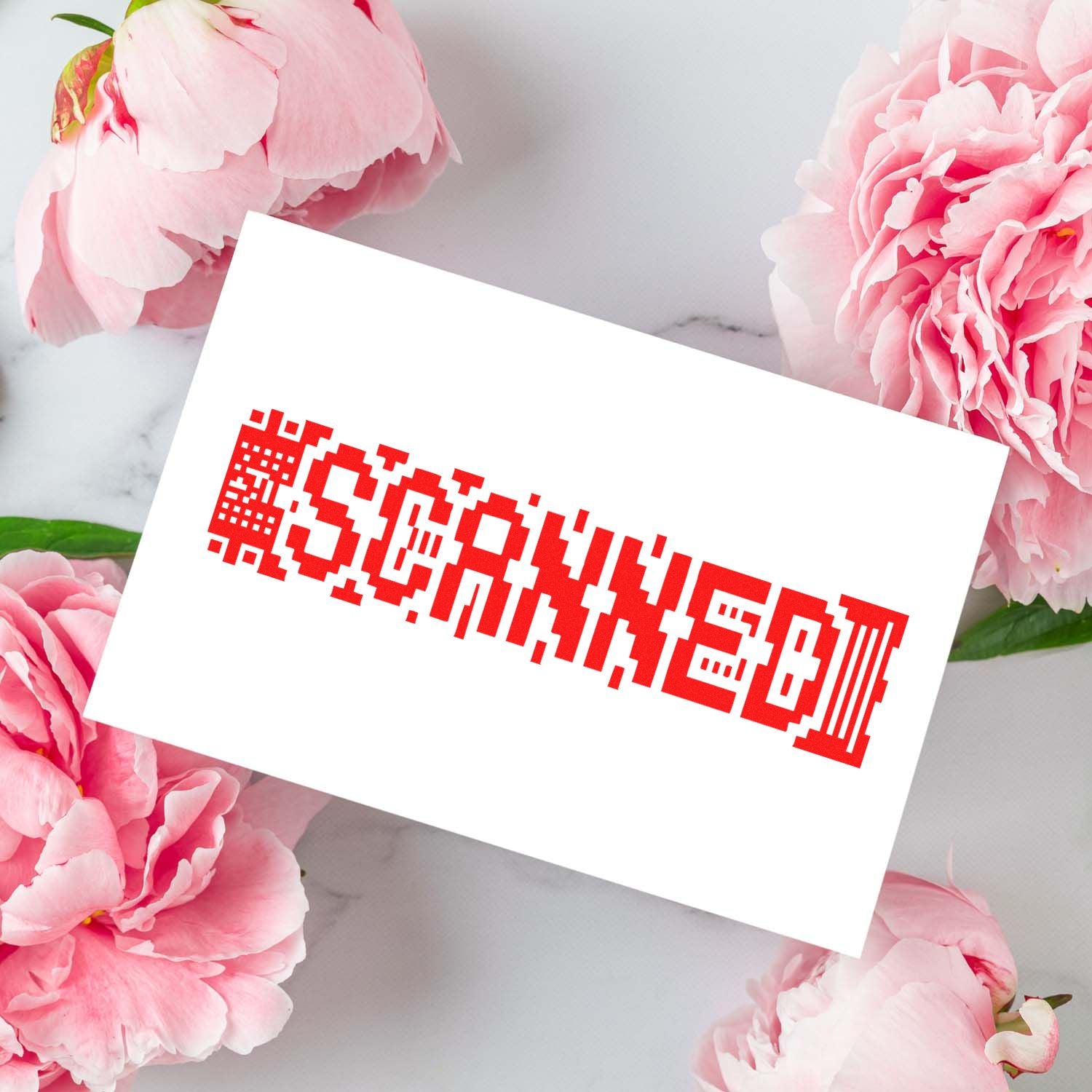 Custom rubber stamp with red pixel-style logo imprint on a white card, surrounded by pink peonies.