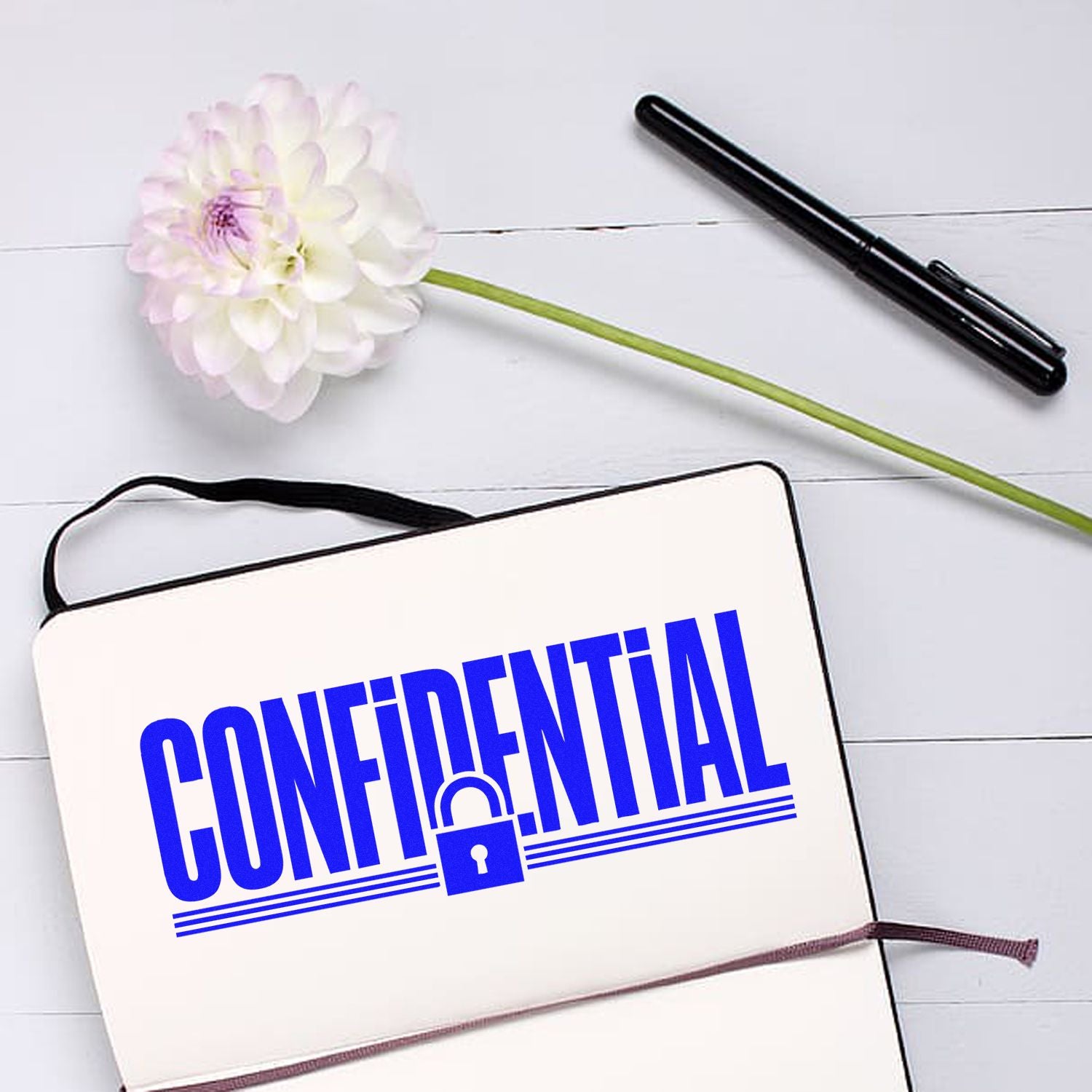 Confidential rubber stamp on notebook, ideal for document security and office privacy labeling.