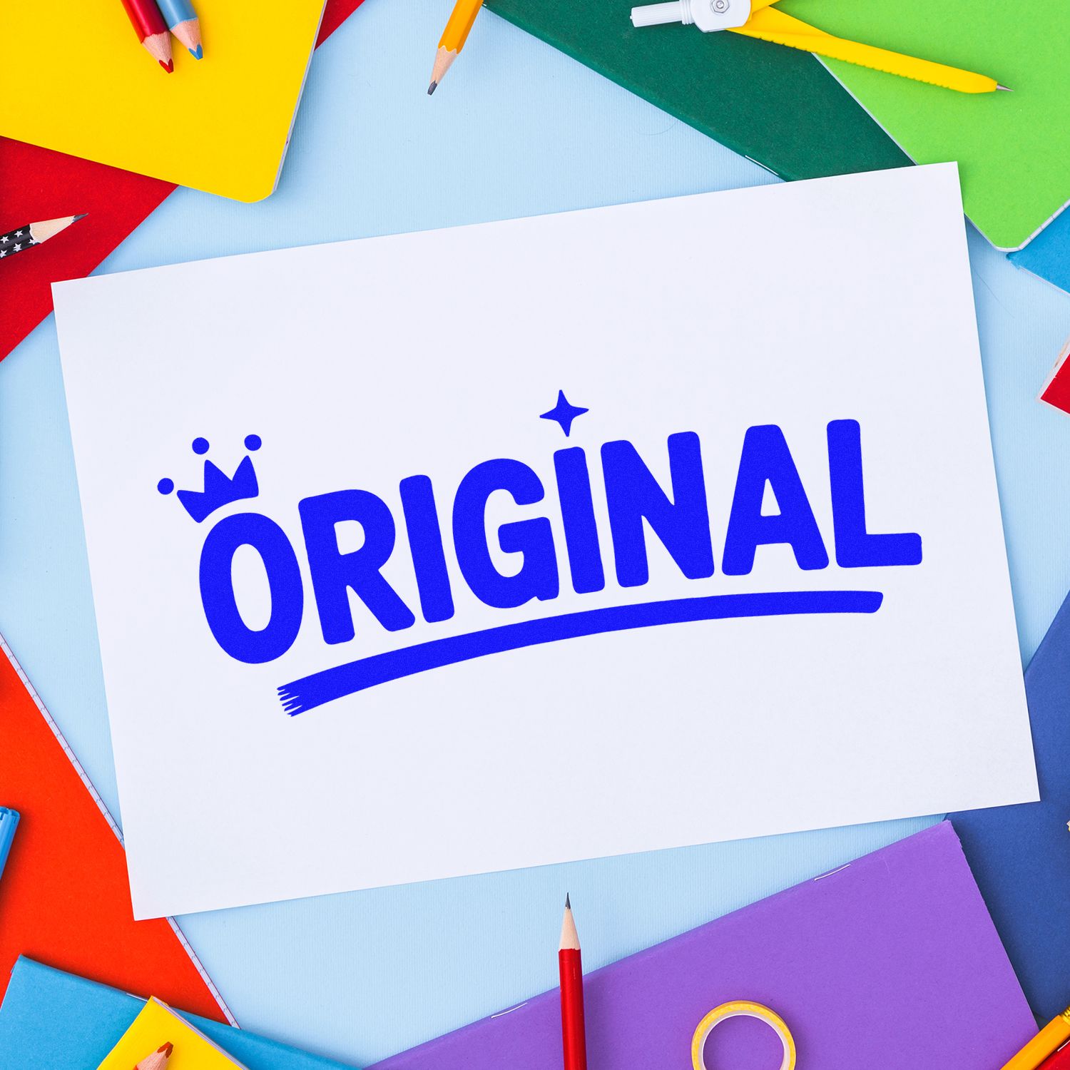 Original rubber stamp design on paper, framed by colorful stationery and pencils for branding, office, or craft use.
