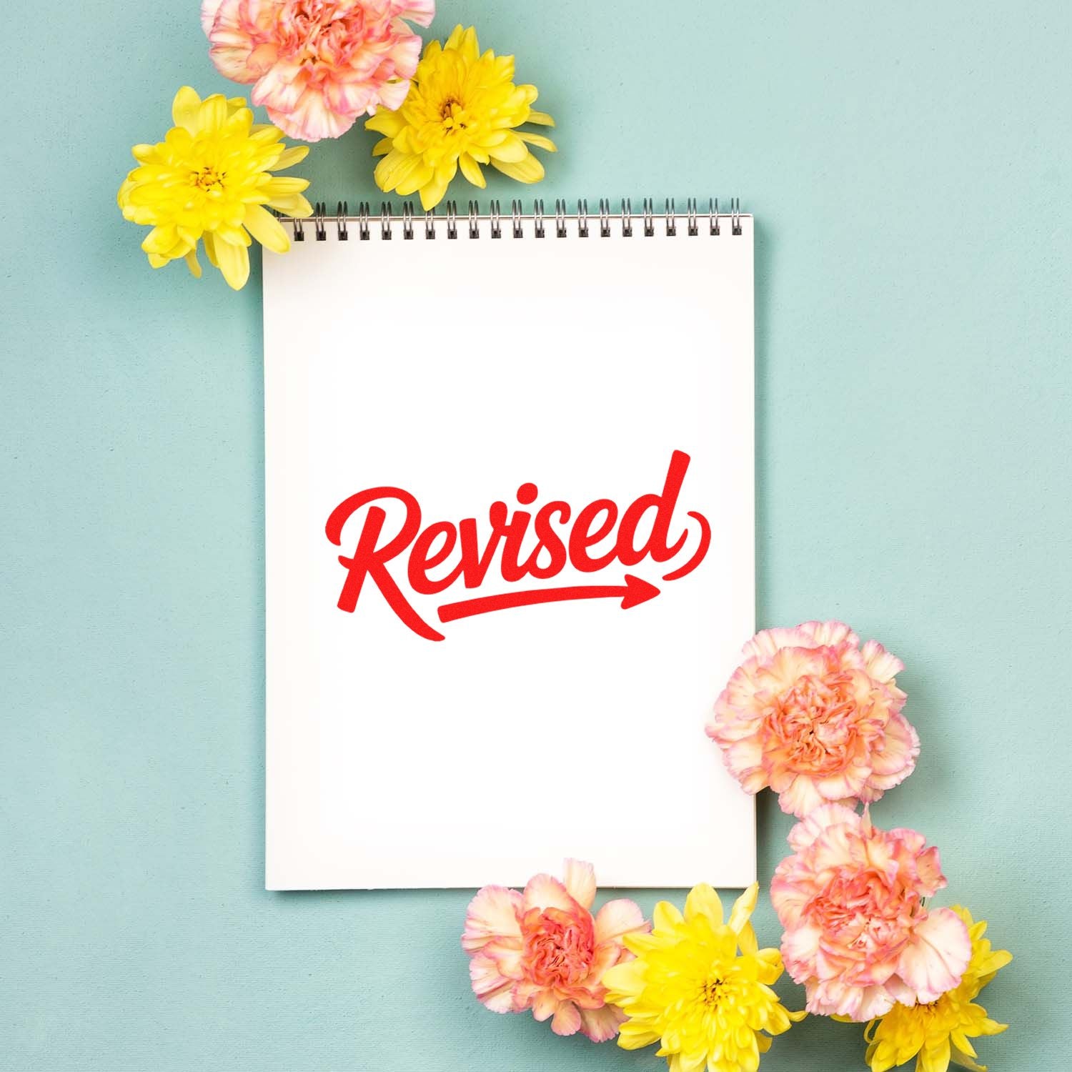 Revised rubber stamp impression on a notebook page for office review, editing, and approval marking.