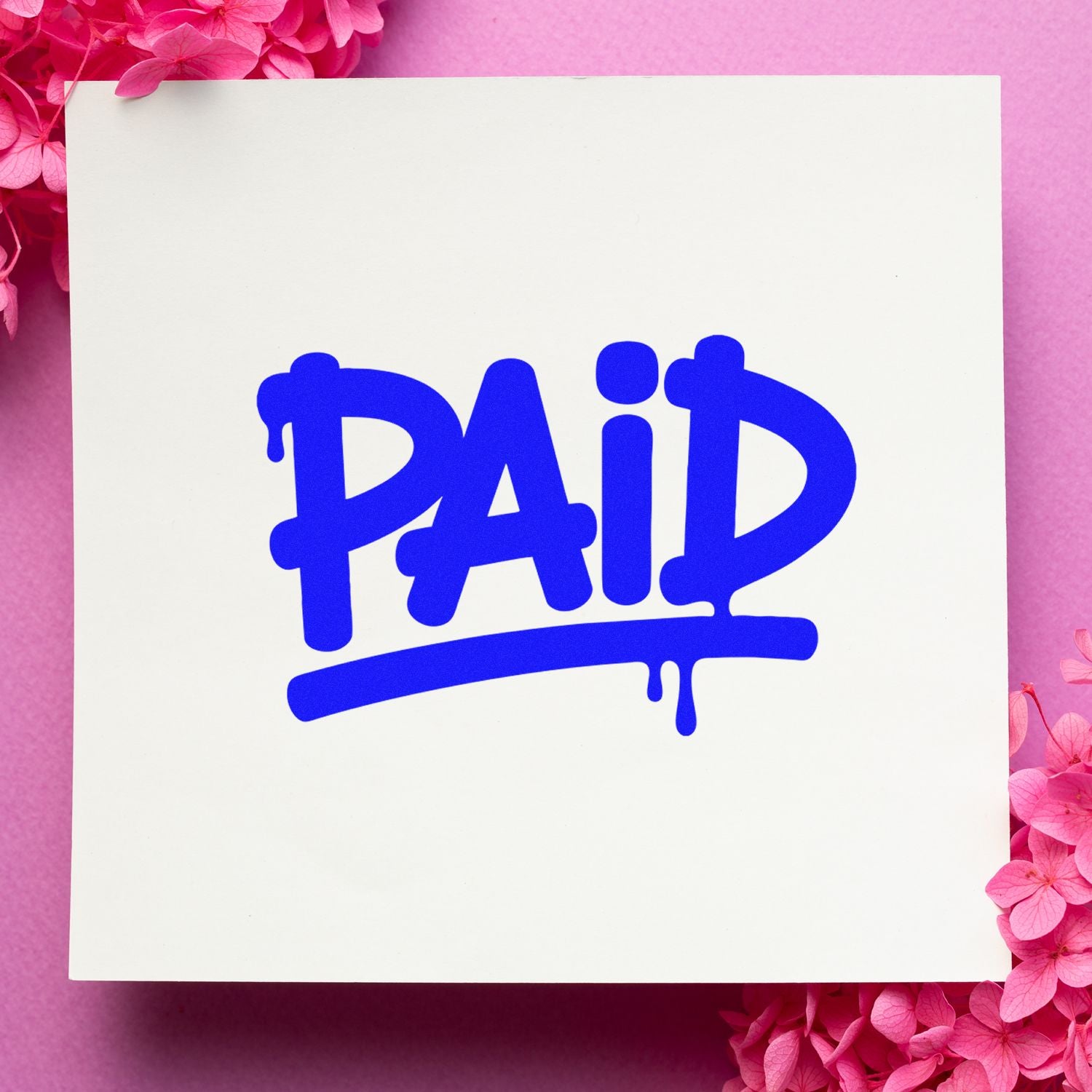 Blue PAID rubber stamp on white card with pink floral background, ideal for invoice and payment approval branding.