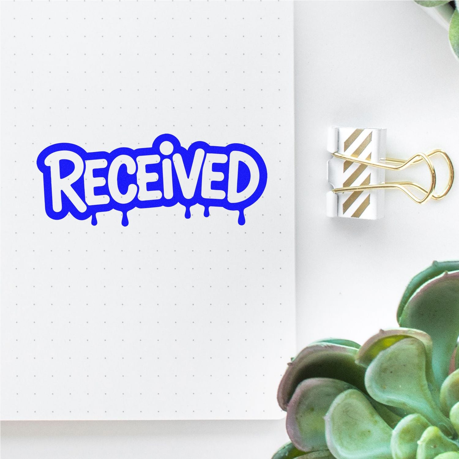 Blue RECEIVED rubber stamp on a dotted planner page for mail, inventory, or office organization.